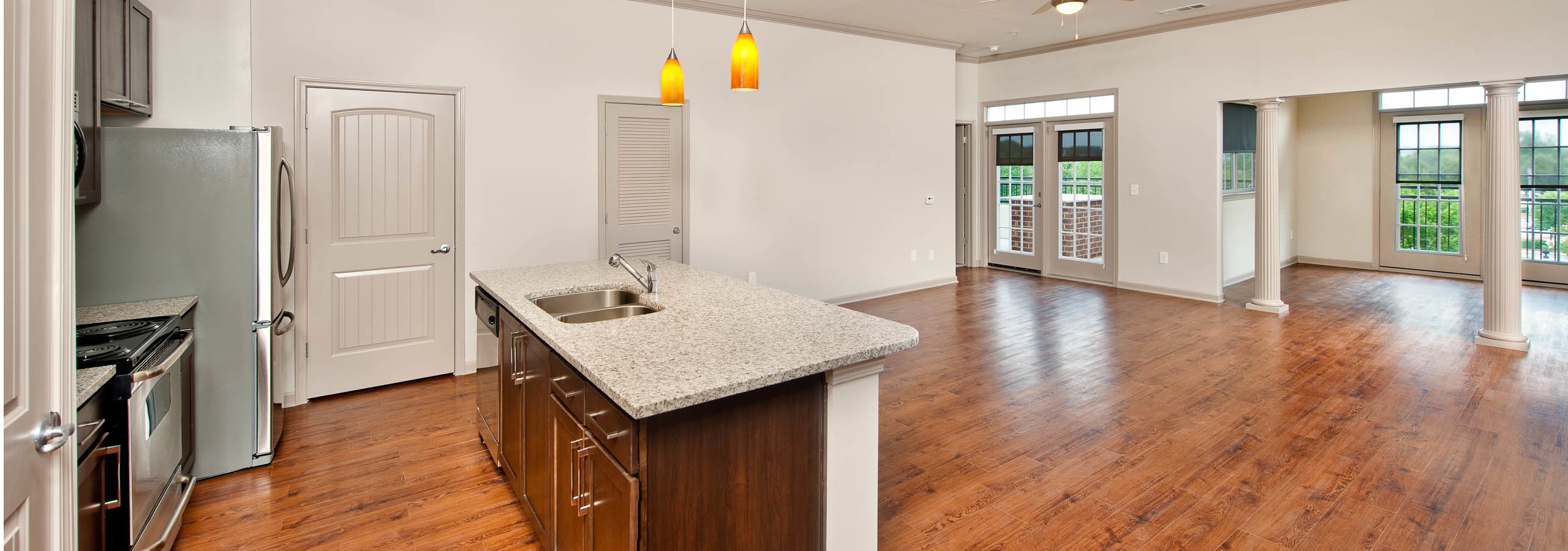 AMLI North Point kitchen with an island and granite countertops with ample free space and pillars in the background