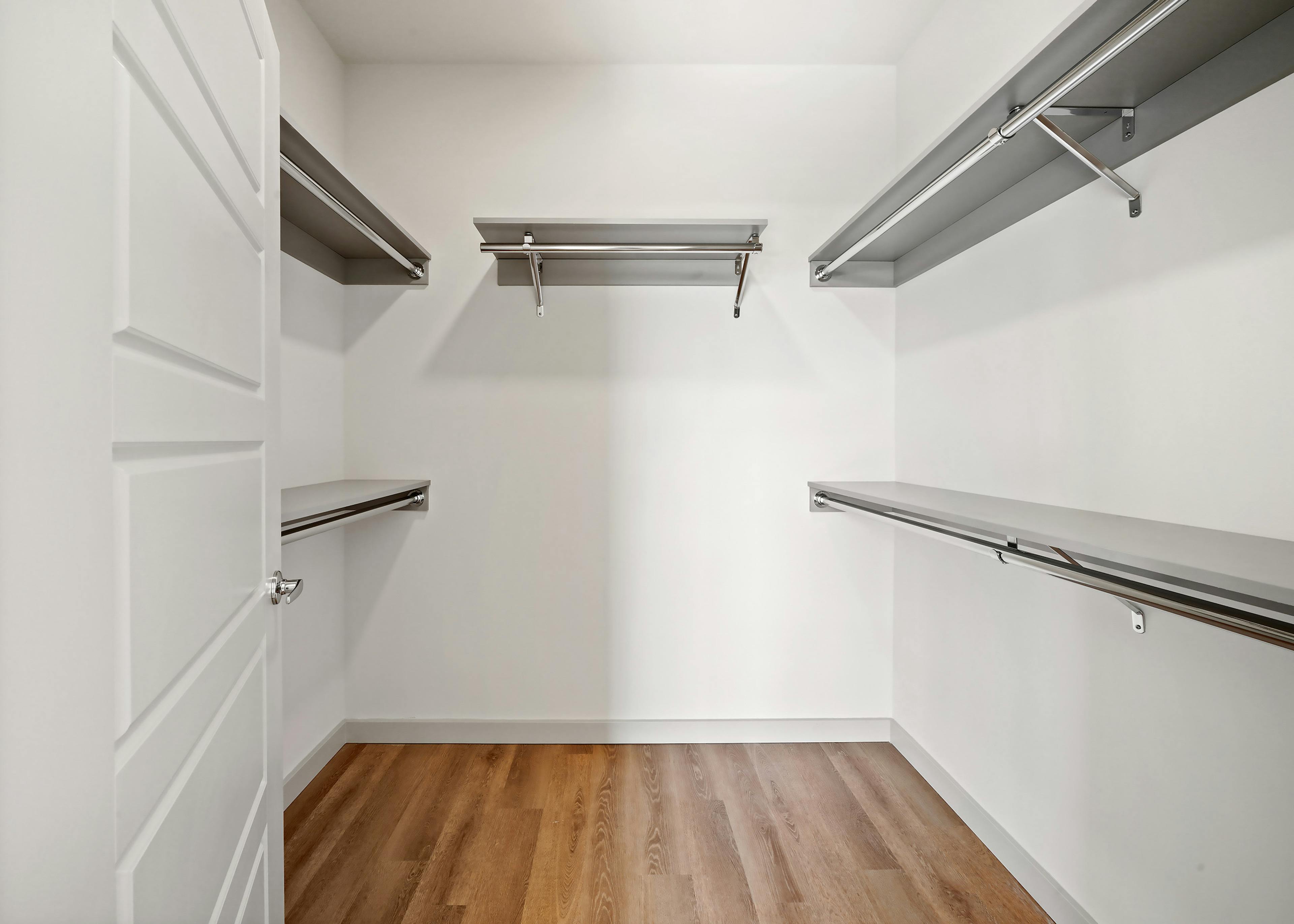Interior view of a large California walk-in closet with five shelves and hanging poles at AMLI Spring District apartments
