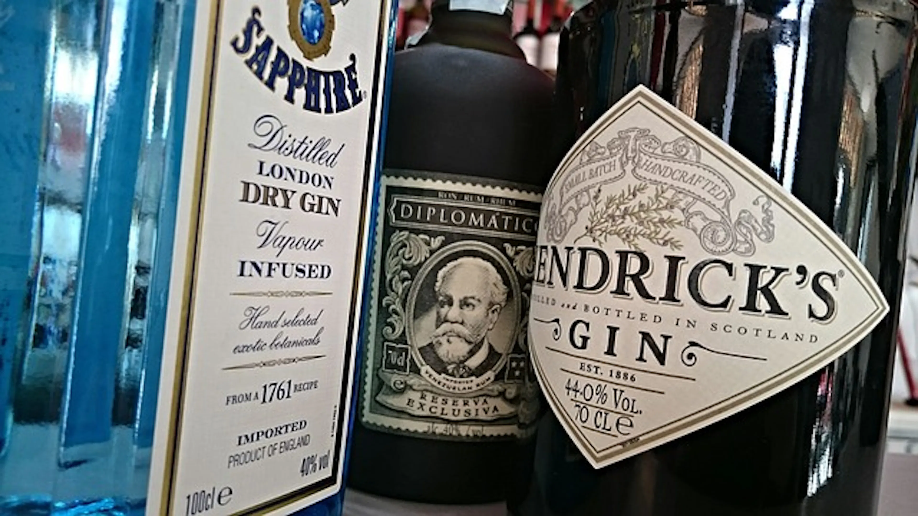 Three bottles of gin from Bombay Sapphire and Hendrick's set beside each other in a close up