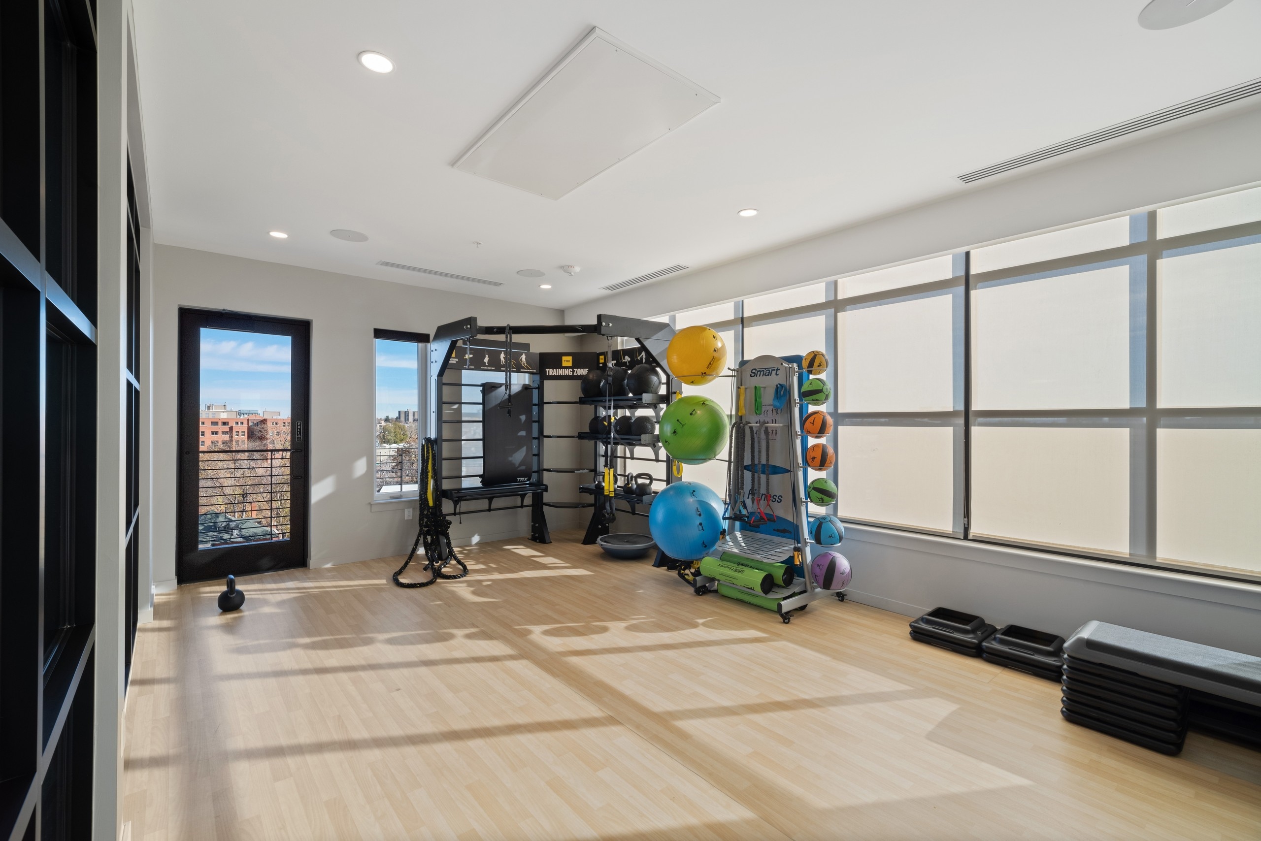 AMLI at Uptown yoga and training studio amenity with light flooring and wide open space featuring racks of equipment along the wall