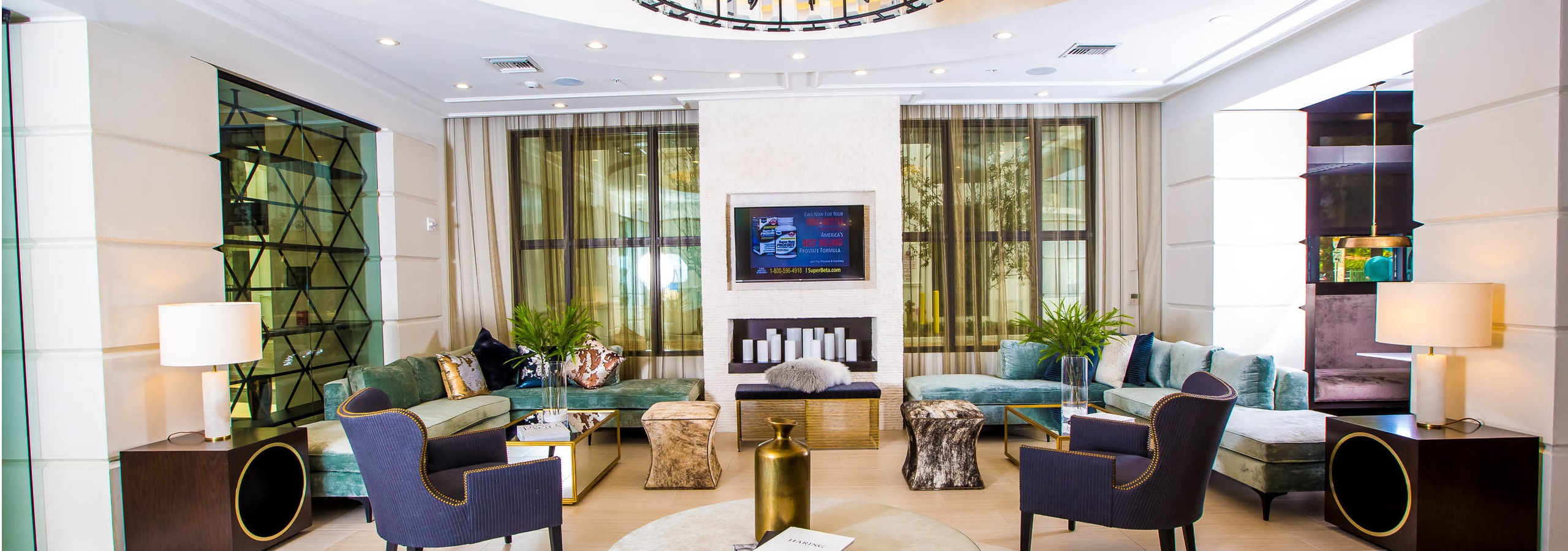 Main resident lounge at AMLI Joya with contemporary living room décor and furniture, electric fireplace and mounted TV