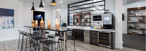 Java bar at AMLI Memorial Heights apartment building with table and chairs in front of serving kitchen and coffee station