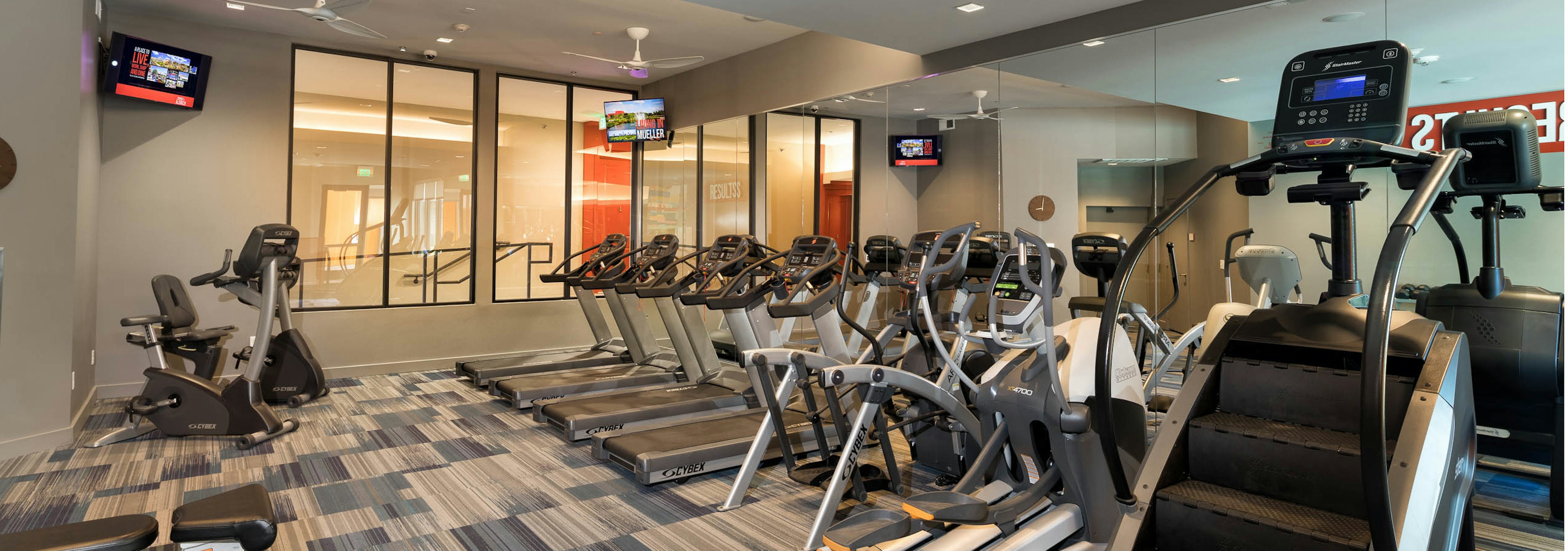 Close up view of cardio machines including a stair climber and multiple treadmills in fitness center at AMLI on Aldrich