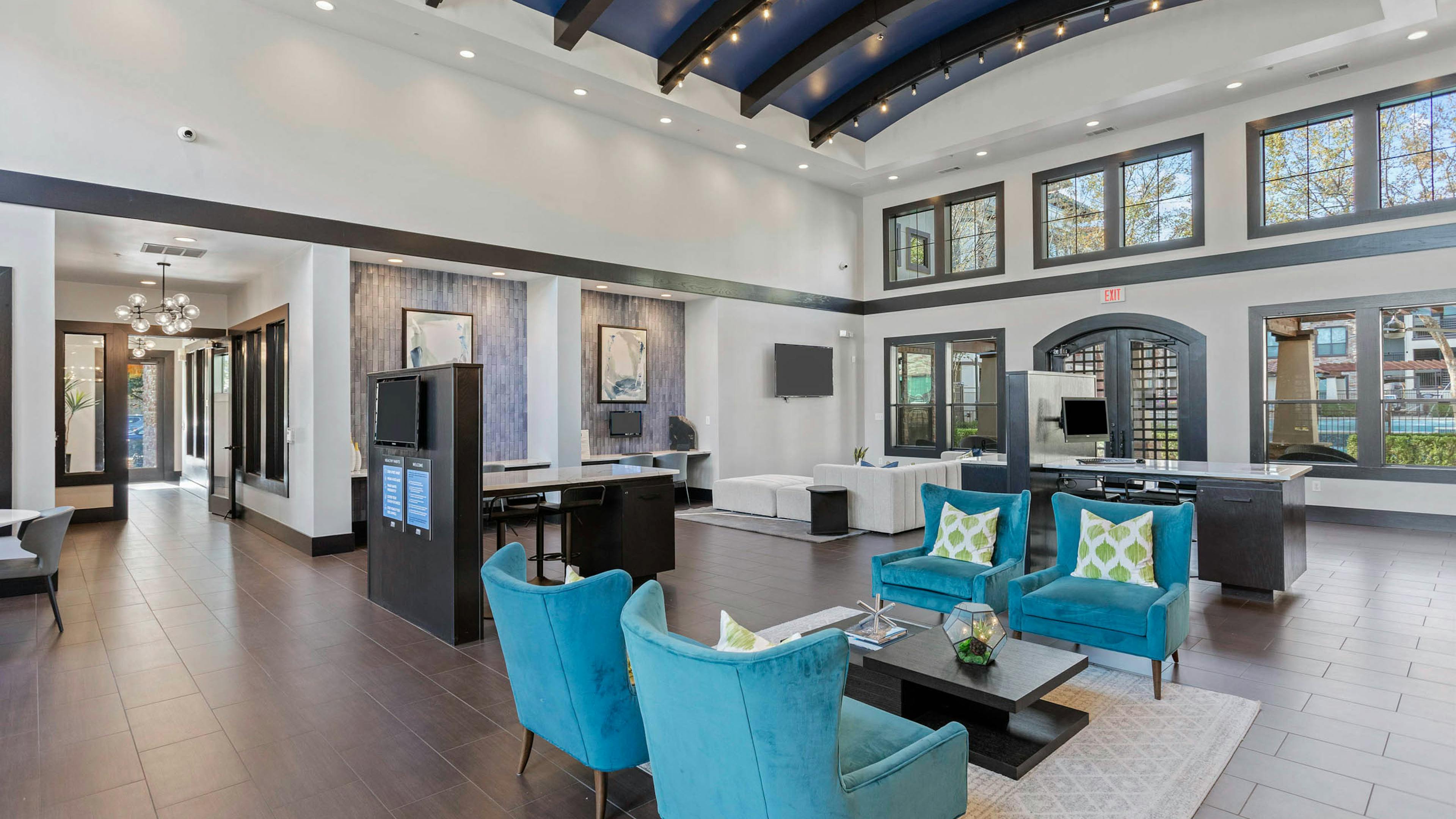 AMLI at Escena apartments leasing office with bright blue lounge chairs and vaulted ceilings equipped with track lighting