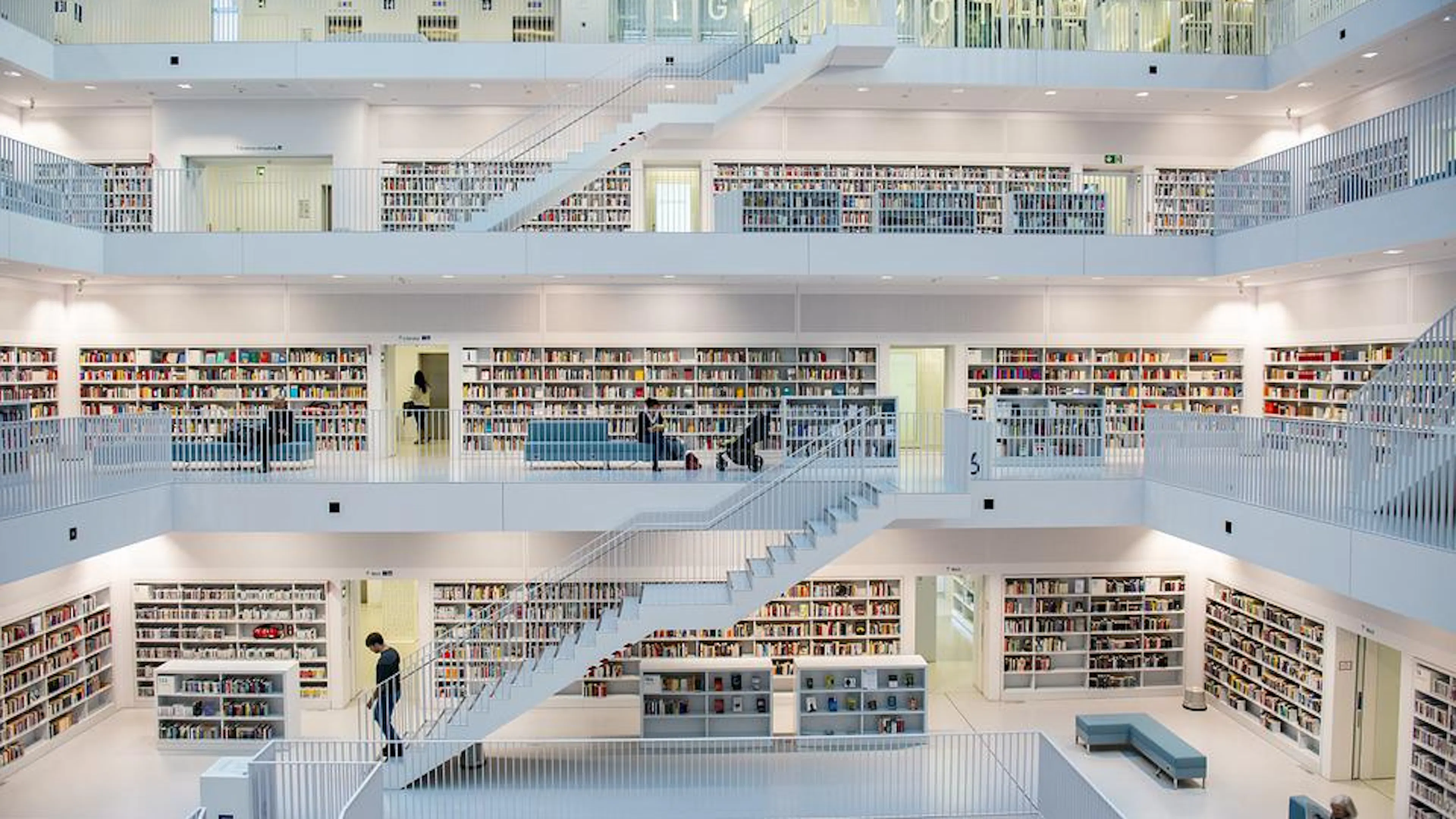 Three floors of a spacious library interior viewed from the center atrium