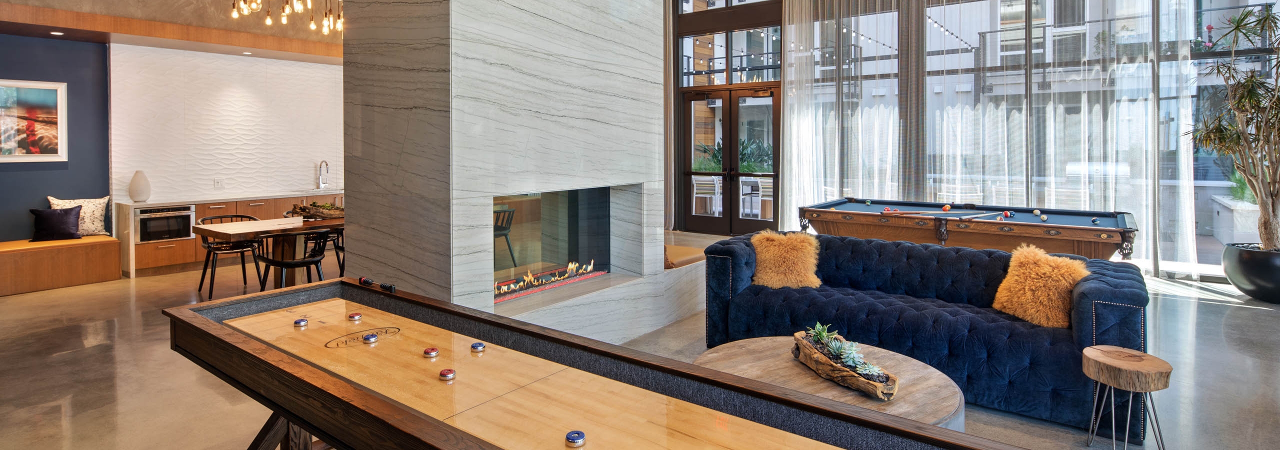 Clubhouse equipped with shuffleboard, pool table and various lounge seating throughout at AMLI Marina Del Rey apartments
