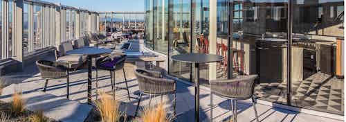 Exterior deck of AMLI Arc with seating and fire pit and views of Seattle