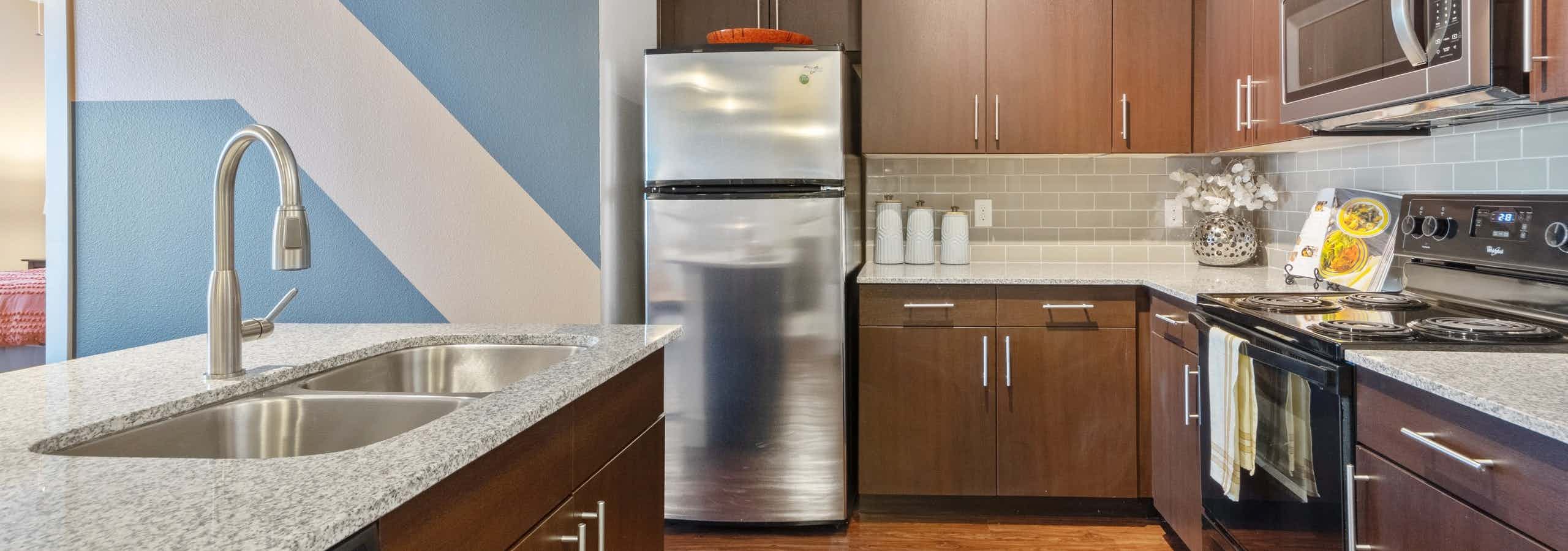 Fully-equipped kitchen with stainless steel refrigerator