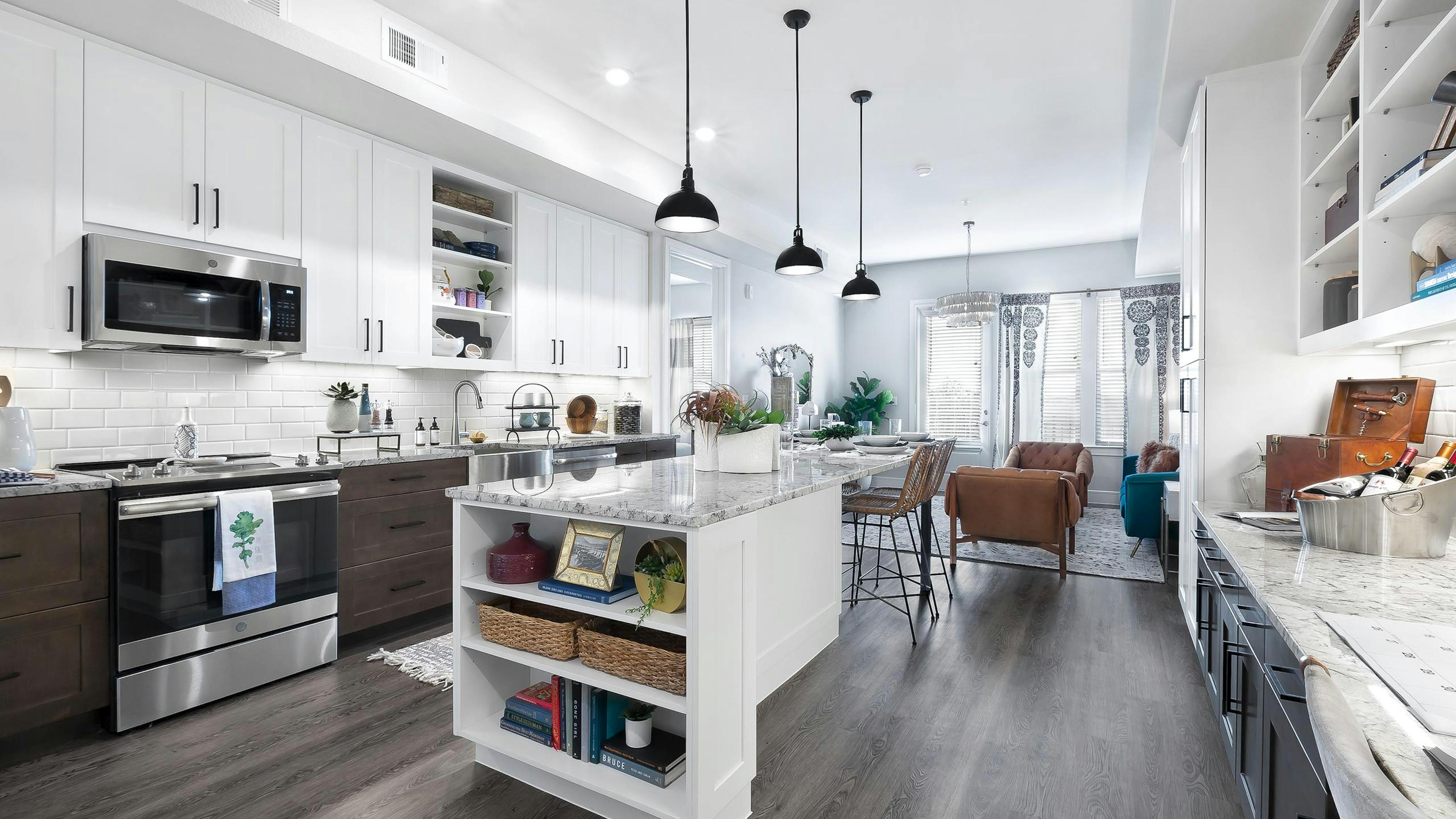 Interior view of kitchen at AMLI Lakeline with white and brown cabinets and a dining island with granite countertops