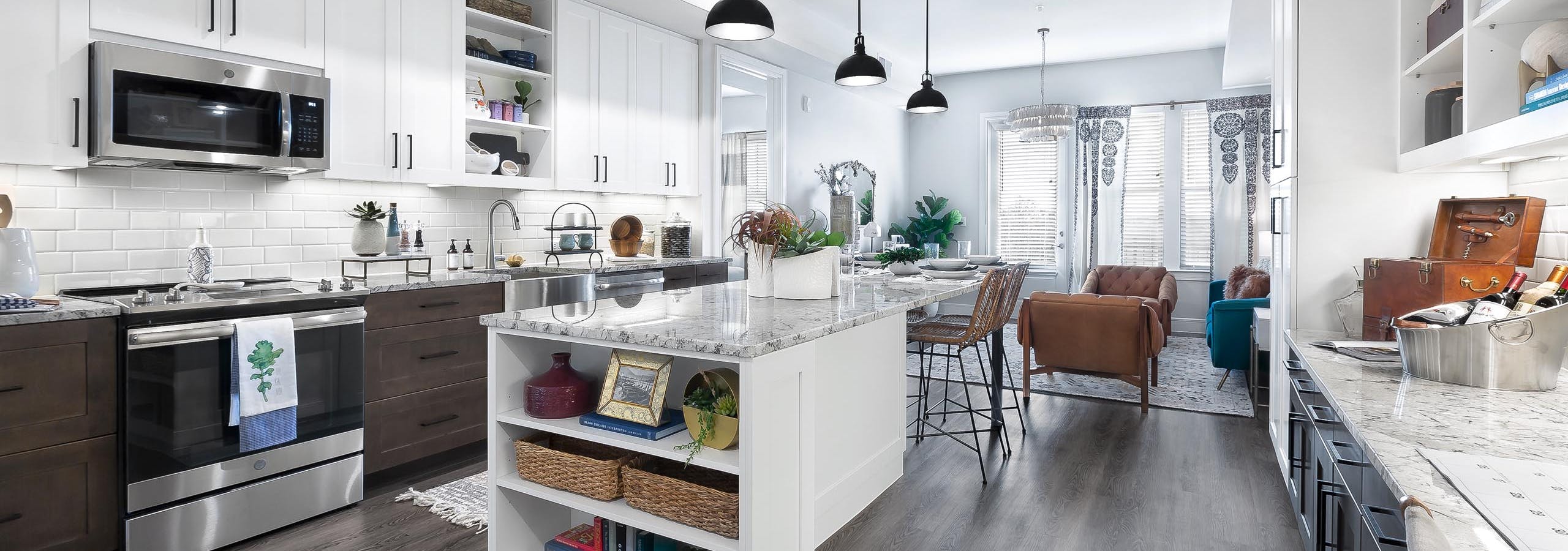 Interior view of kitchen at AMLI Lakeline with white and brown cabinets and a dining island with granite countertops