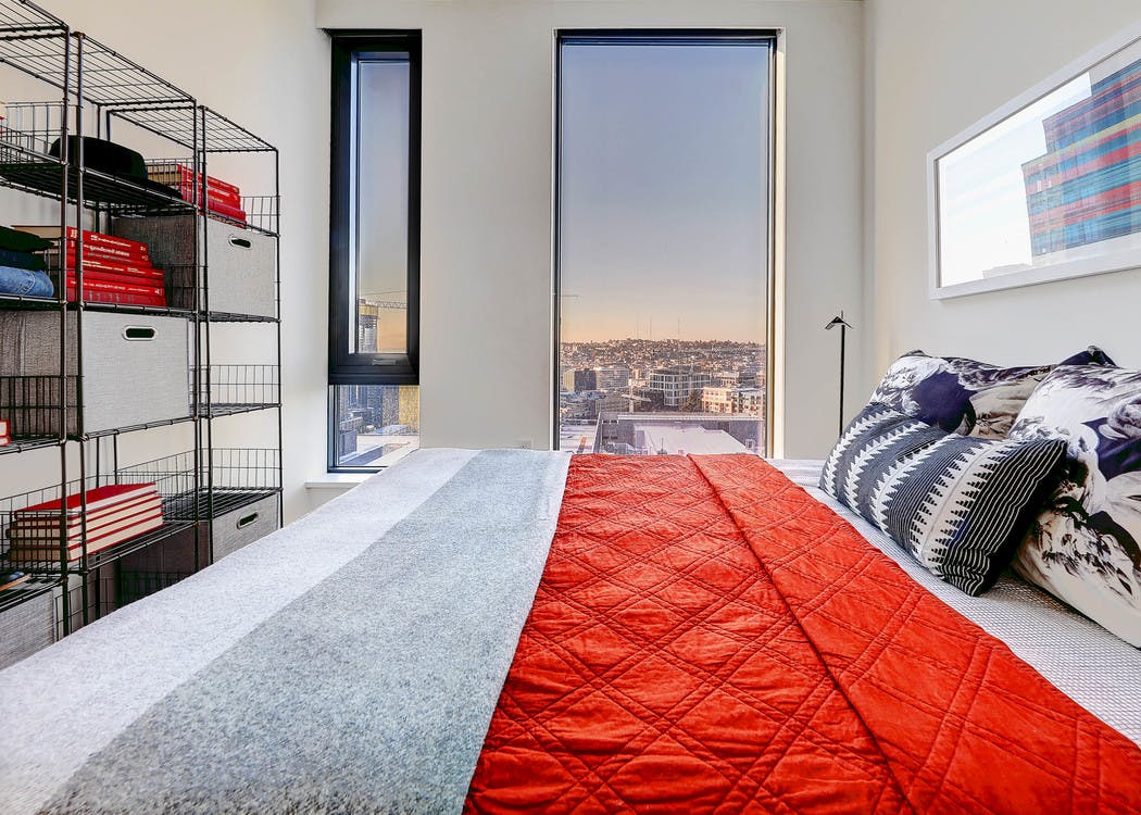 Interior view of apartment of AMLI Arc bedroom with white walls large window with view and space for a queen bed
