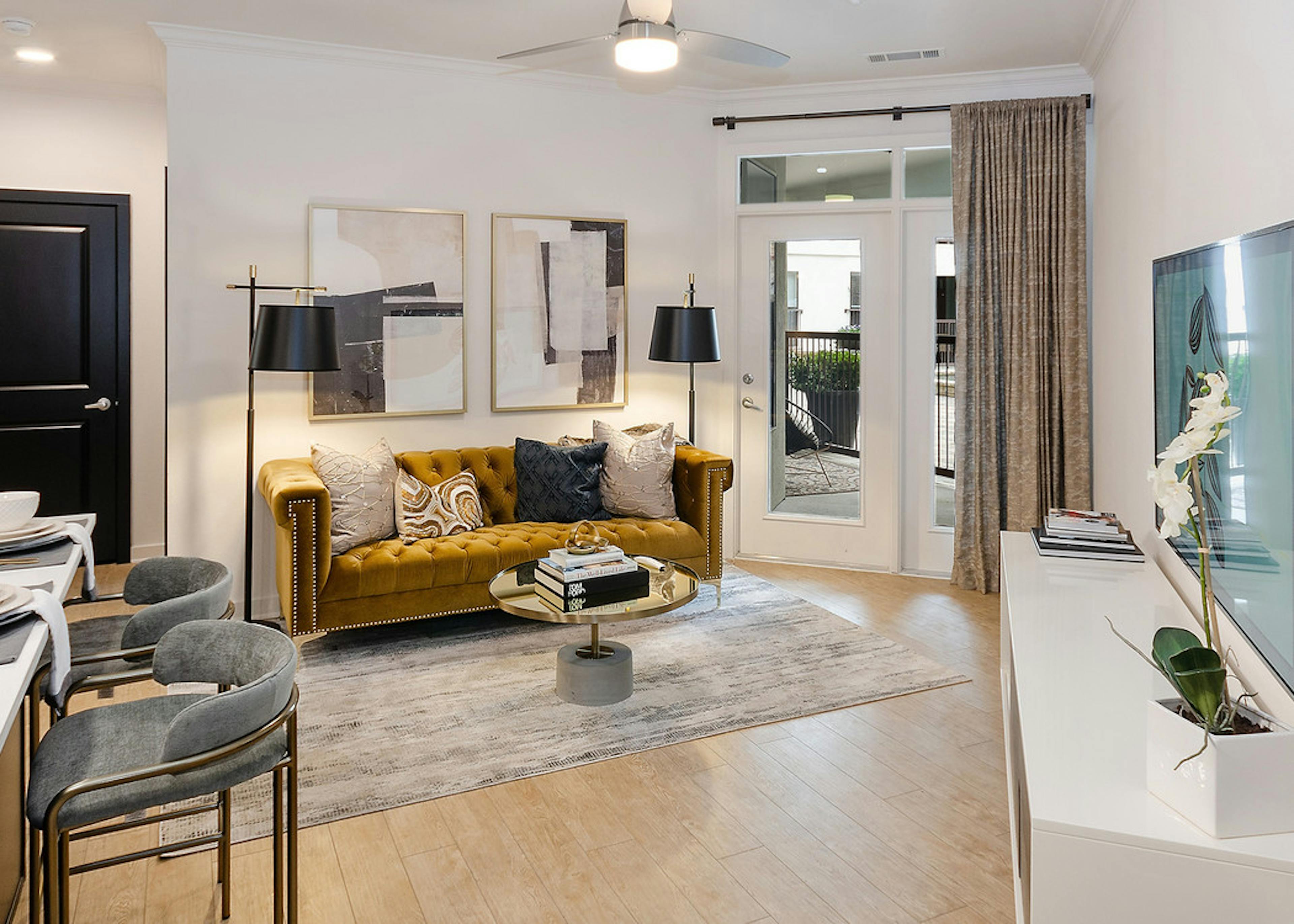 Interior view of AMLI Quadrangle living room with balcony doors and light hardwood with an elegant retro decor style