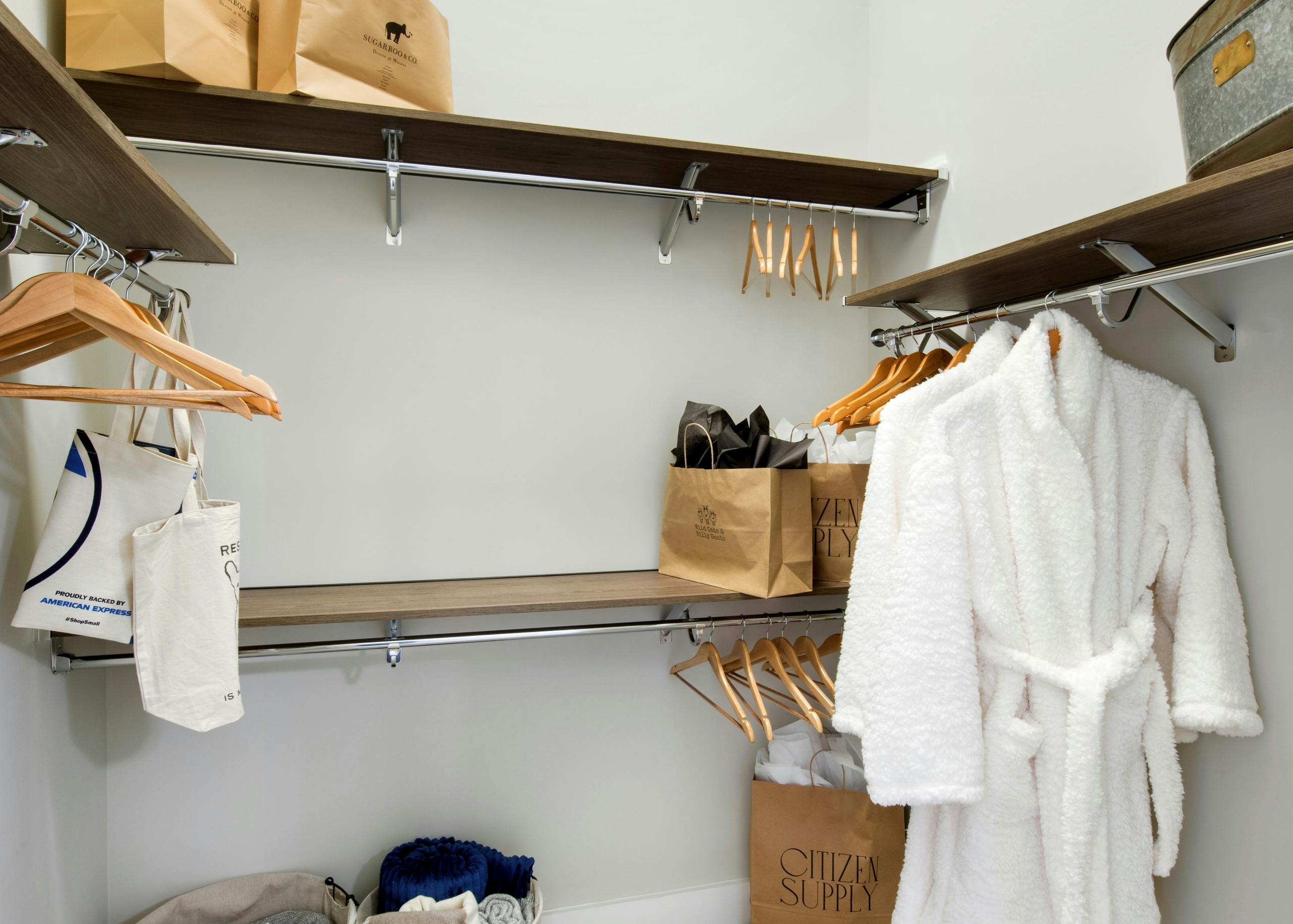 Interior view of AMLI Decatur apartment with spacious walk-in closet with hangers and shopping bags on built-in shelves