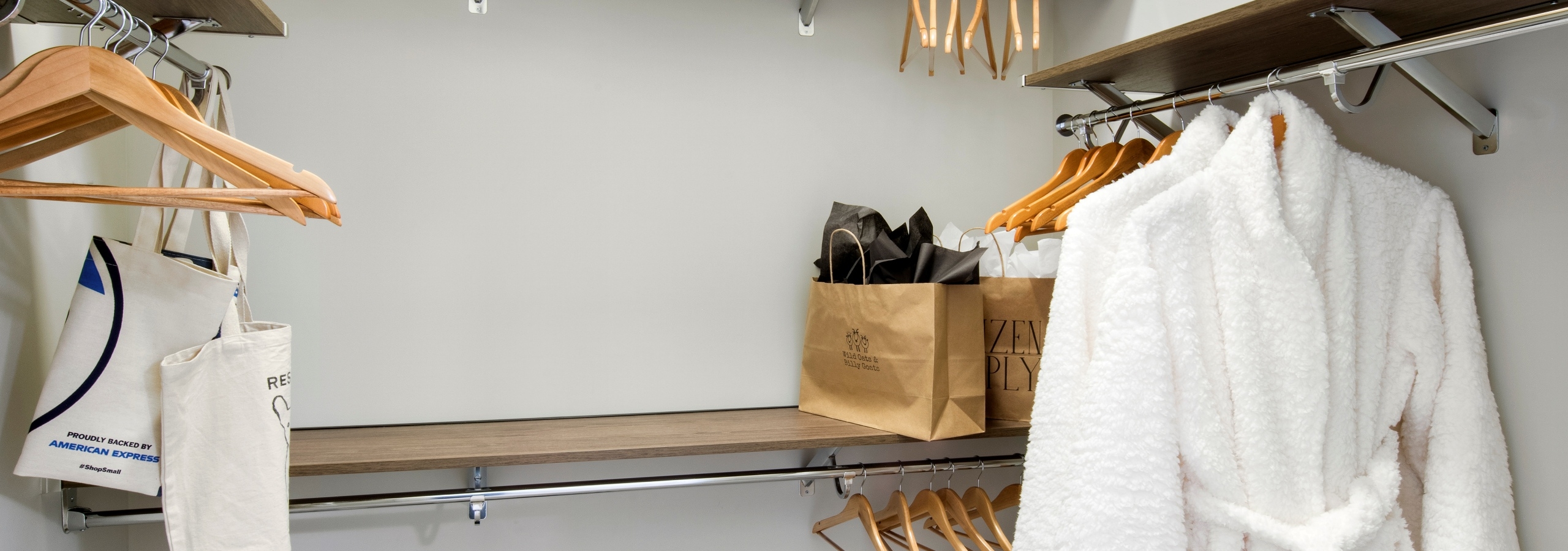 Interior view of AMLI Decatur apartment with spacious walk in closet with hangers and shopping bags on built in shelves