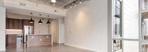 Interior view of kitchen at AMLI on 2nd with an island and stainless steel appliances with modern black light fixtures