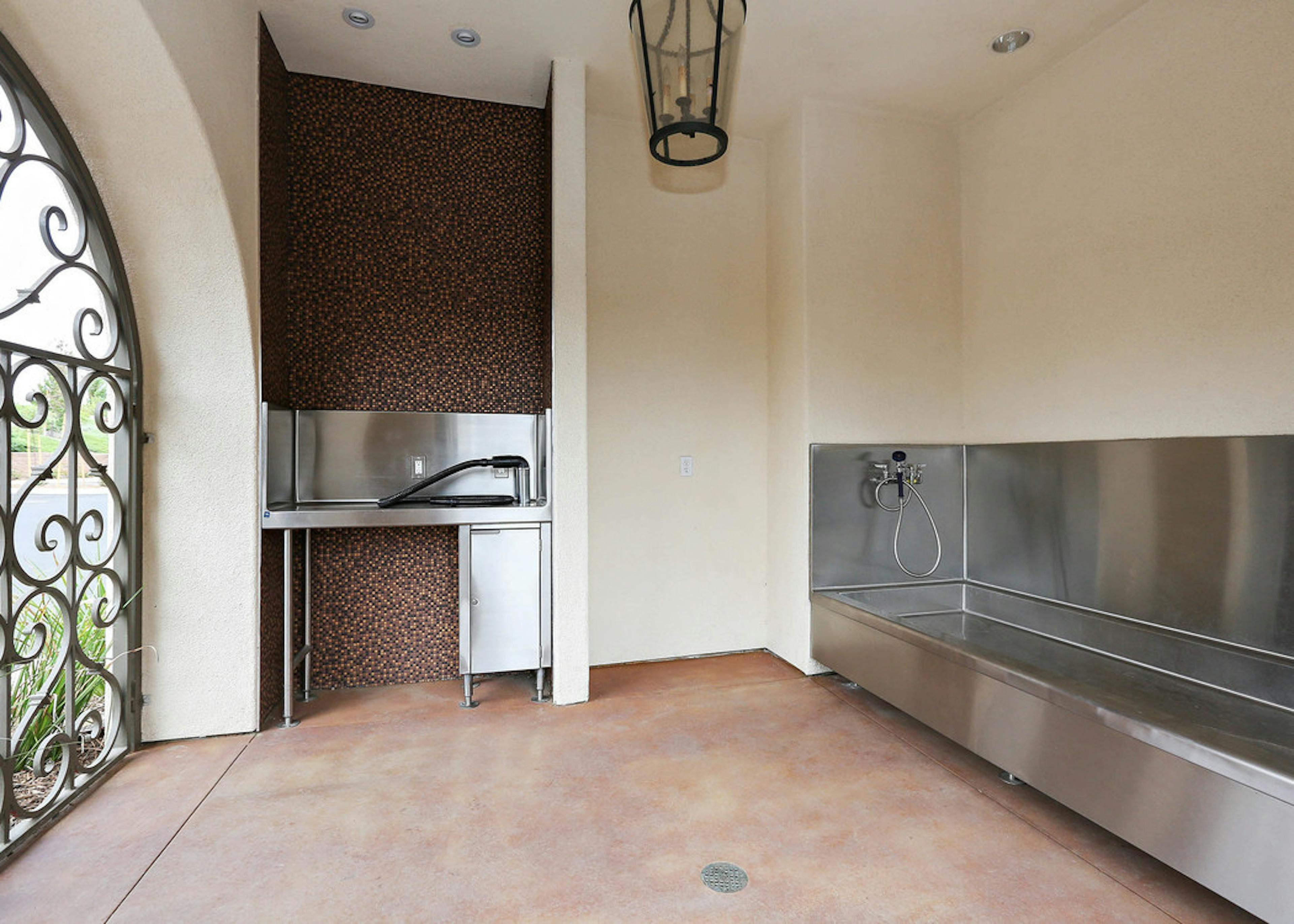 Interior daytime view of paw wash at AMLI Spanish Hills apartment building with stainless tub, grooming counter and dryer