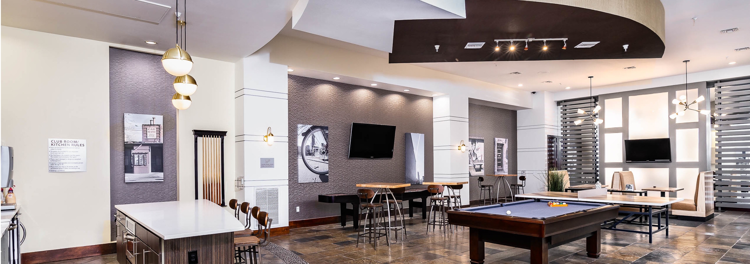 Interior view of the club room at AMLI Park Avenue apartments with a pool table and multiple seating areas and wall art work
