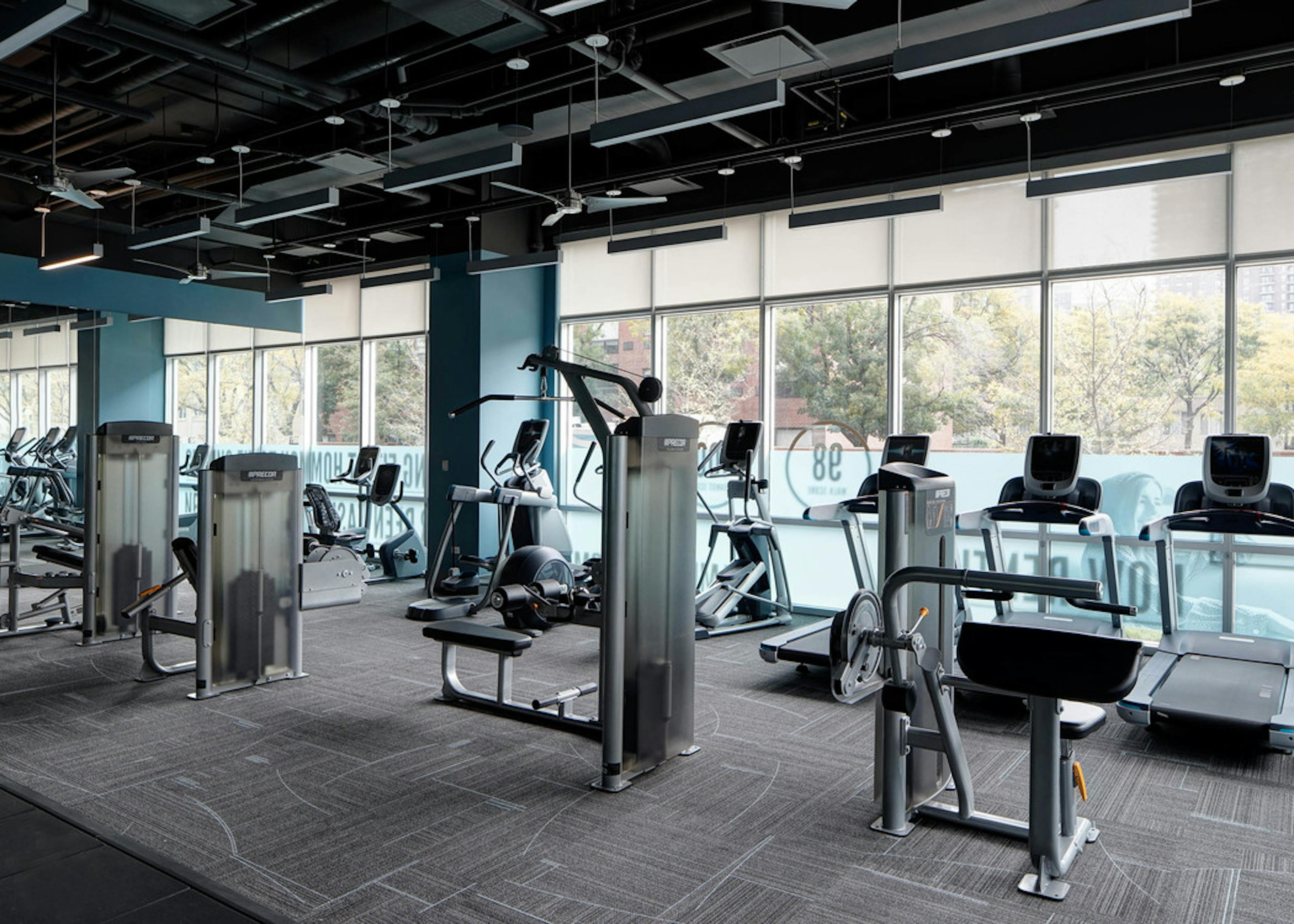 Interior view of the fitness center at AMLI Lofts featuring treadmills and elliptical machines as well as other equipment