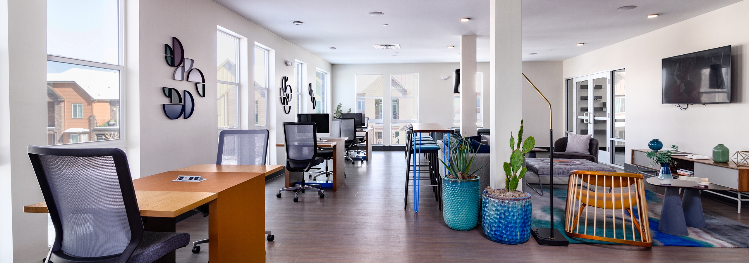 Daytime view of Business center at AMLI Littleton Village apartments with work desks, seating areas and decorative wall art