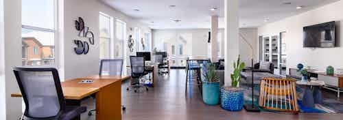 Daytime view of Business center at AMLI Littleton Village apartments with work desks, seating areas and decorative wall art