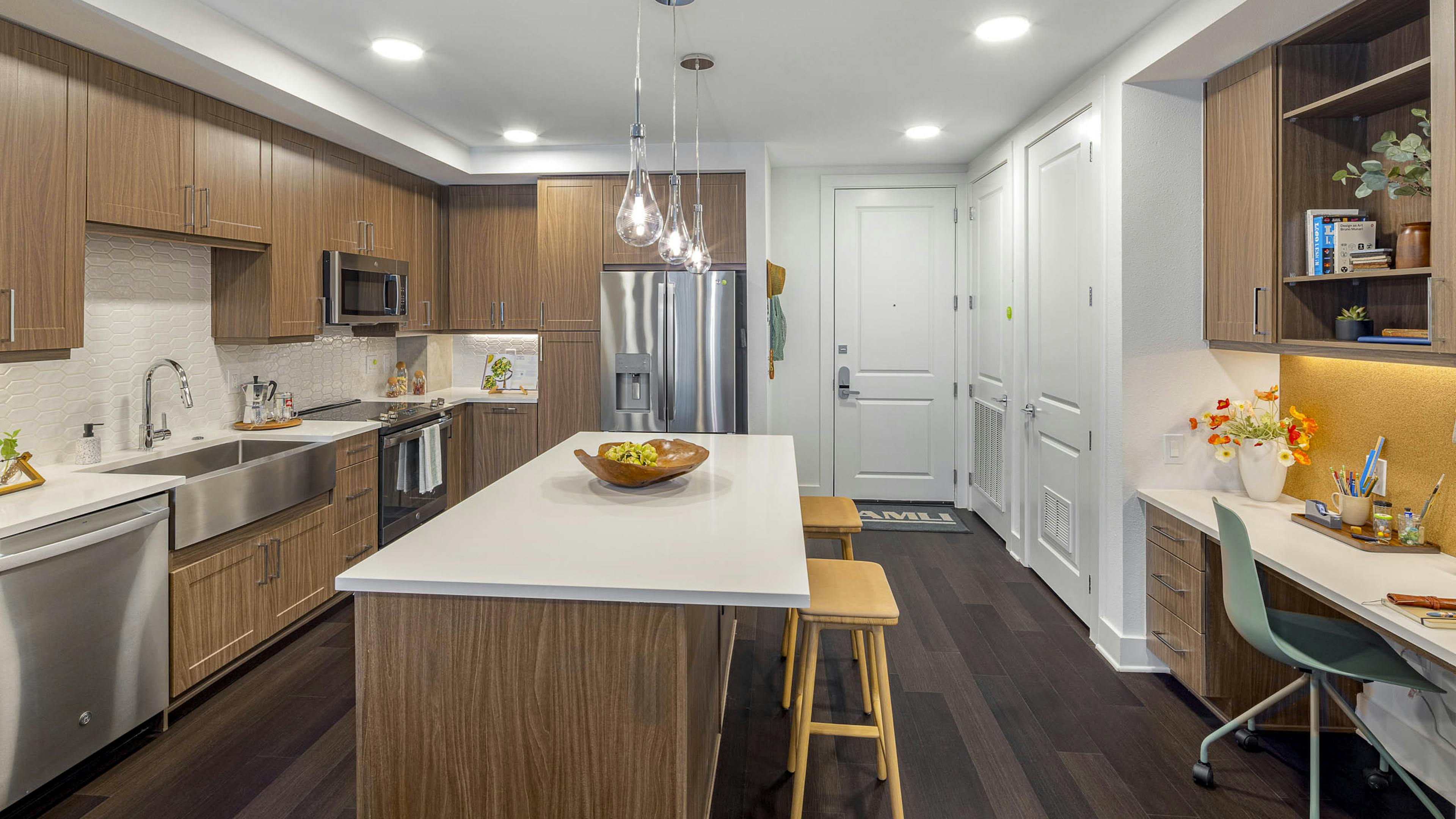 AMLI Branch Park kitchen with white quartz island and wood cabinets and stainless steel appliances and farmhouse sink