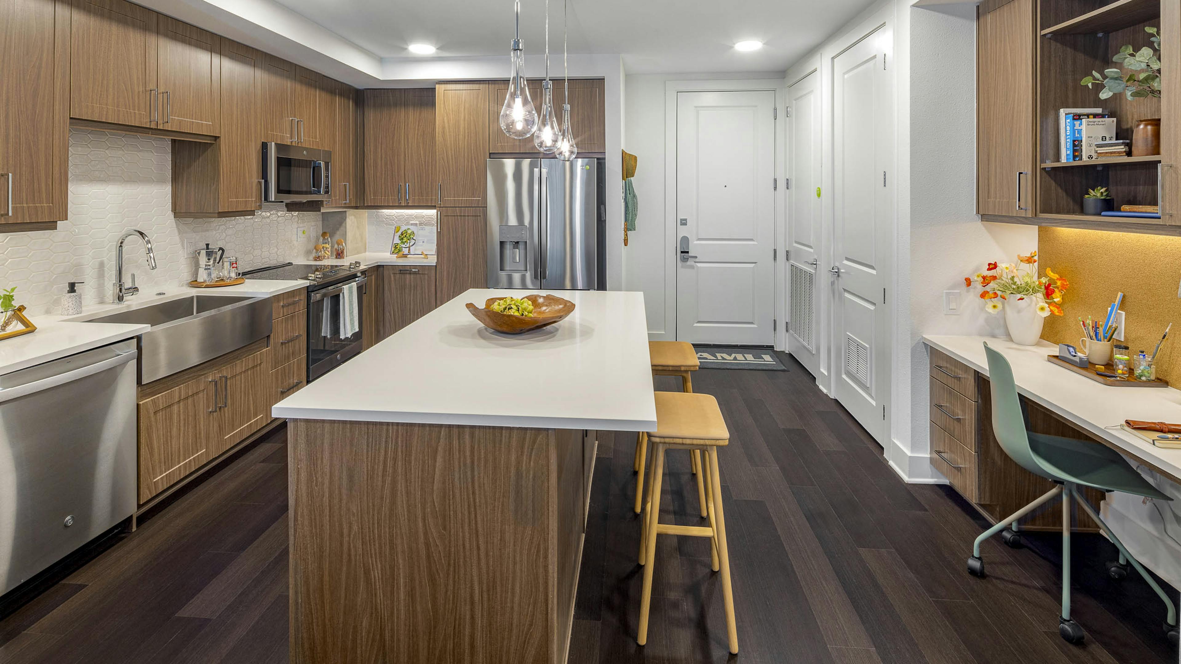 AMLI Branch Park kitchen with white quartz island and wood cabinets and stainless steel appliances and farmhouse sink