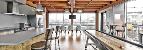 AMLI Mark 24 apartments rooftop clubroom with kitchen and shuffleboard table and table with six chairs and large windows