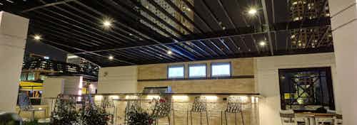 Exterior view of the AMLI River North apartment community sheltered rooftop grill area with bar stools at an extended counter