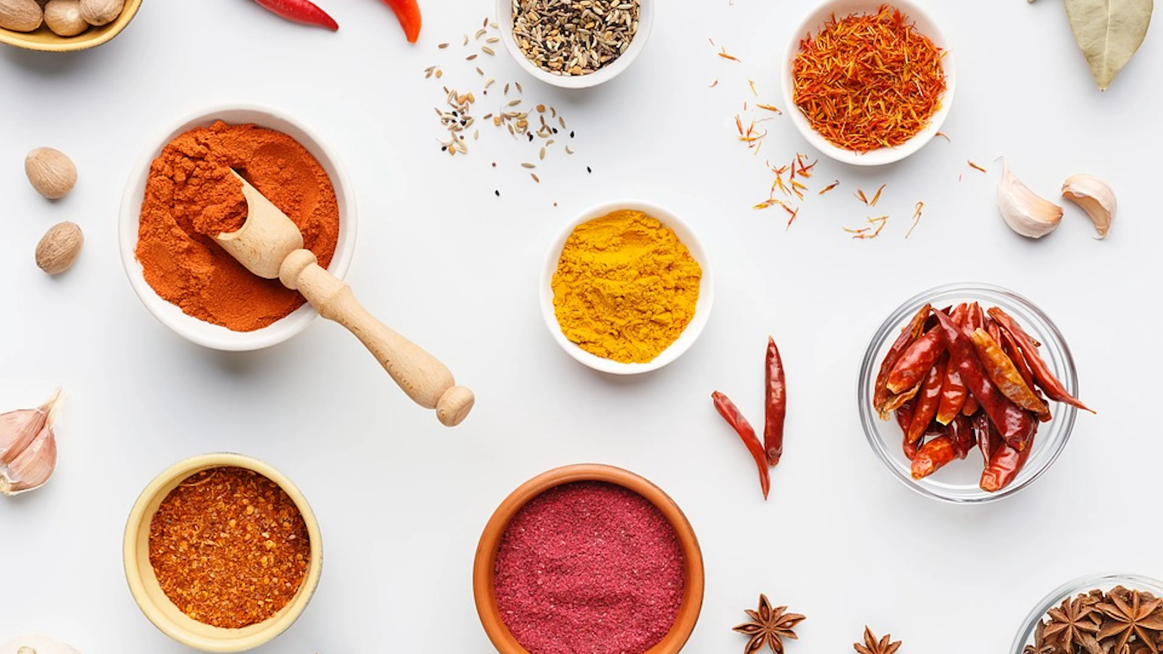 Overhead shot of little white bowls full of colorful spices