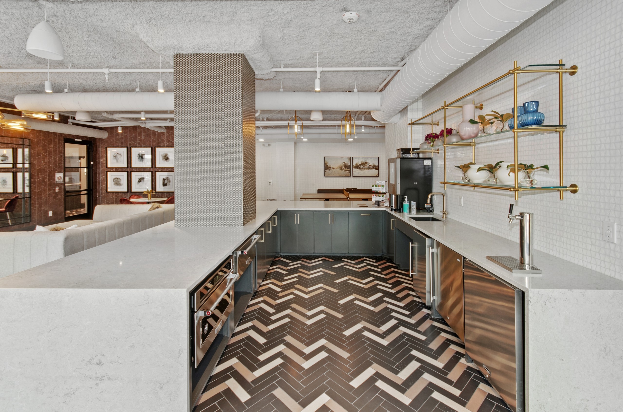 AMLI Quadrangle apartments resident kitchen equipped with Starbucks machine and stainless steel appliances on a tile floor