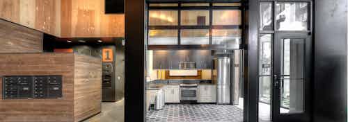 Interior view of resident lounge with kitchen glass garage door that rolls up fridge and view of conference room table and theater