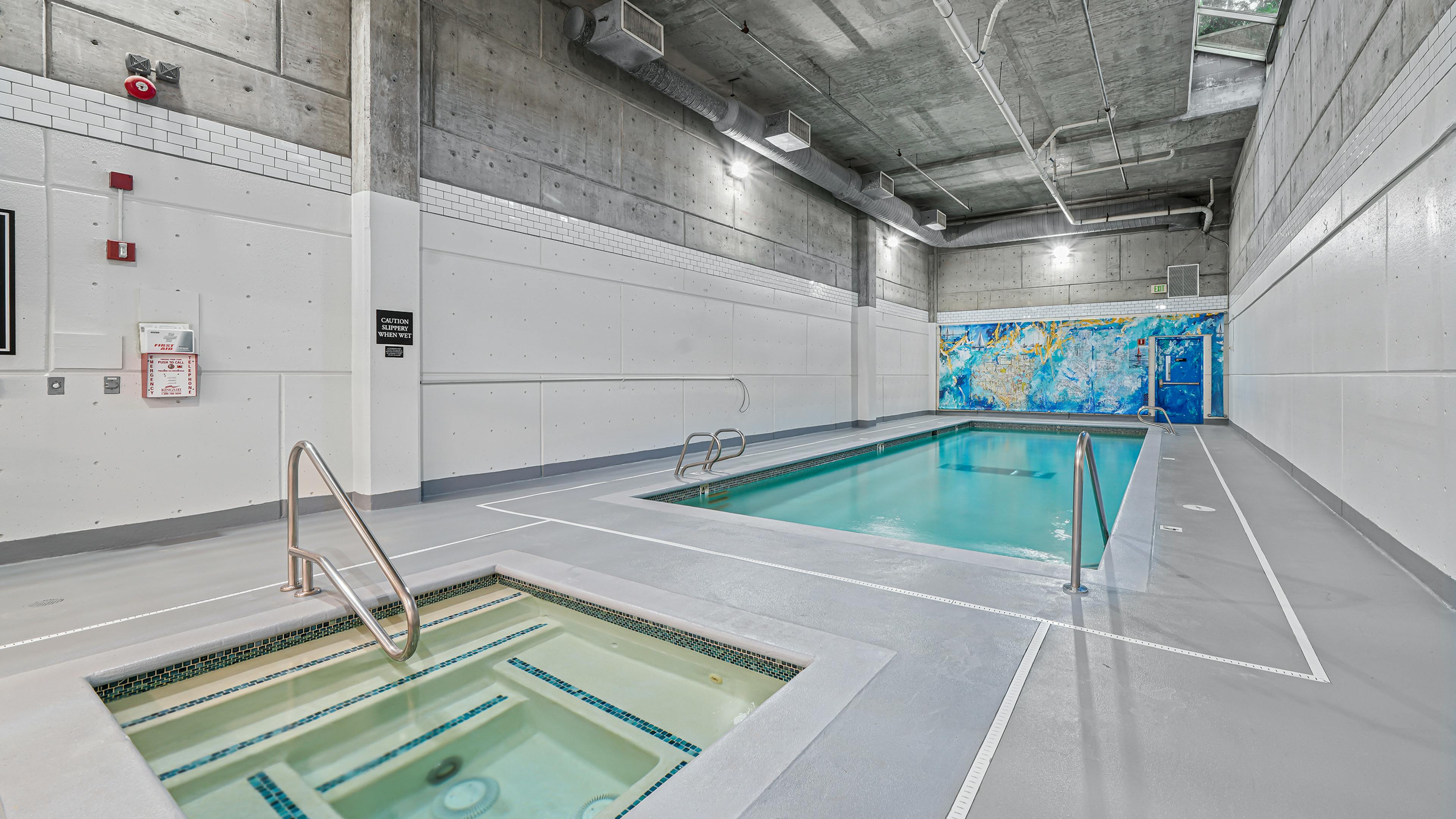 AMLI Bellevue Park indoor pool and spa with colorful mural on the back wall and light grey floors and white walls