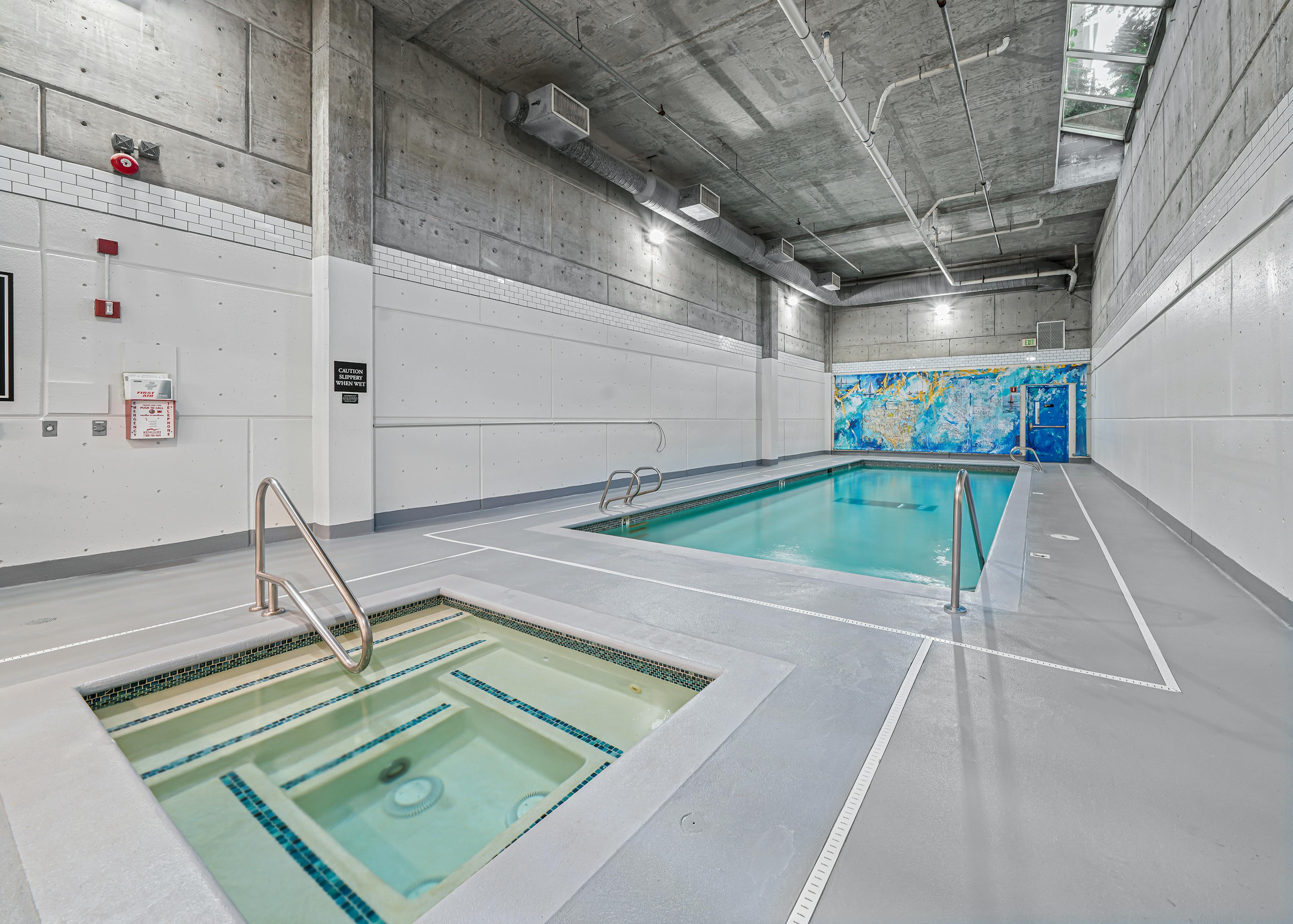 AMLI Bellevue Park indoor pool and spa with colorful mural on the back wall and light grey floors and white walls