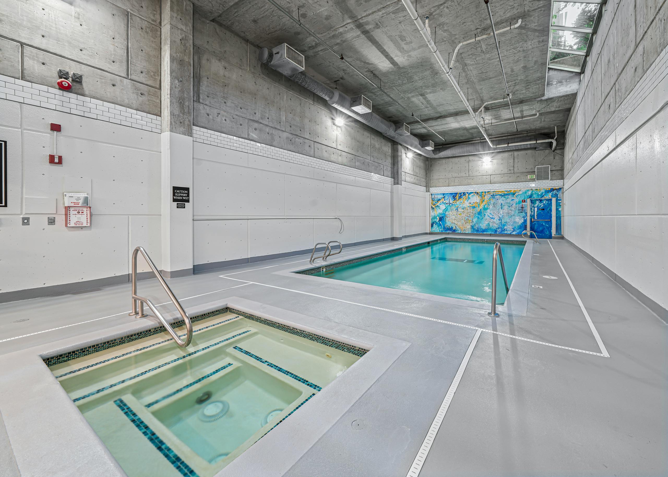 AMLI Bellevue Park indoor pool and spa with colorful mural on the back wall and light grey floors and white walls