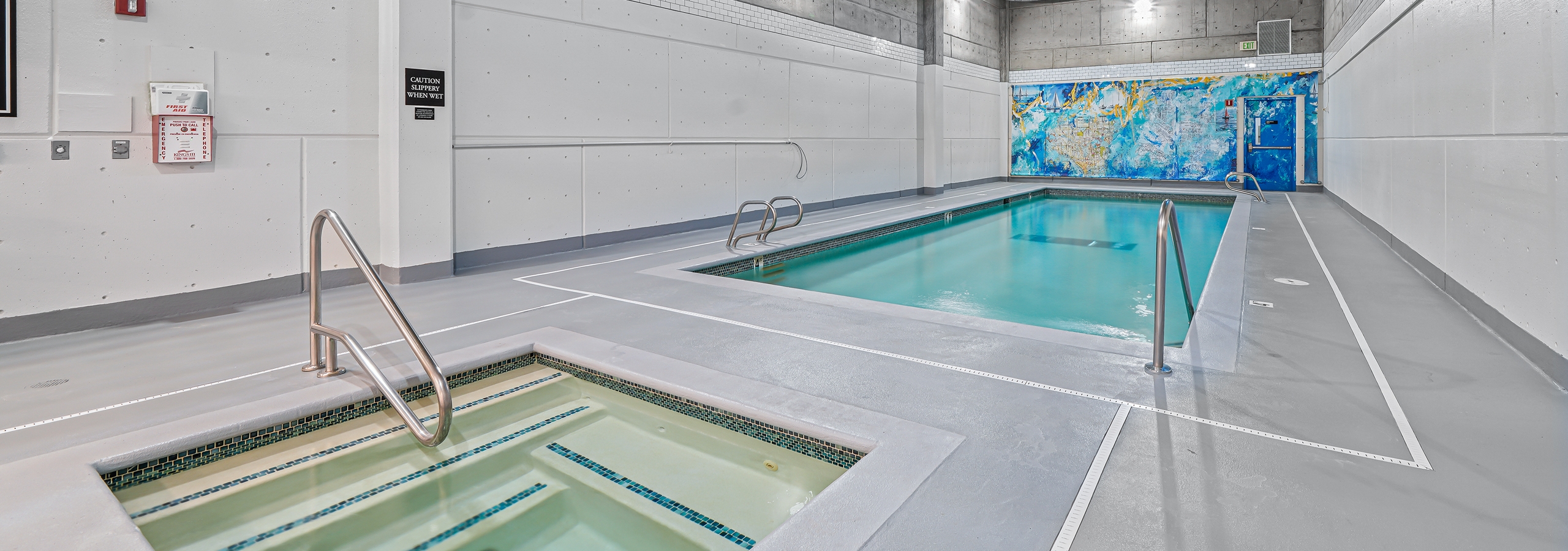 AMLI Bellevue Park indoor pool and spa with colorful mural on the back wall and light grey floors and white walls