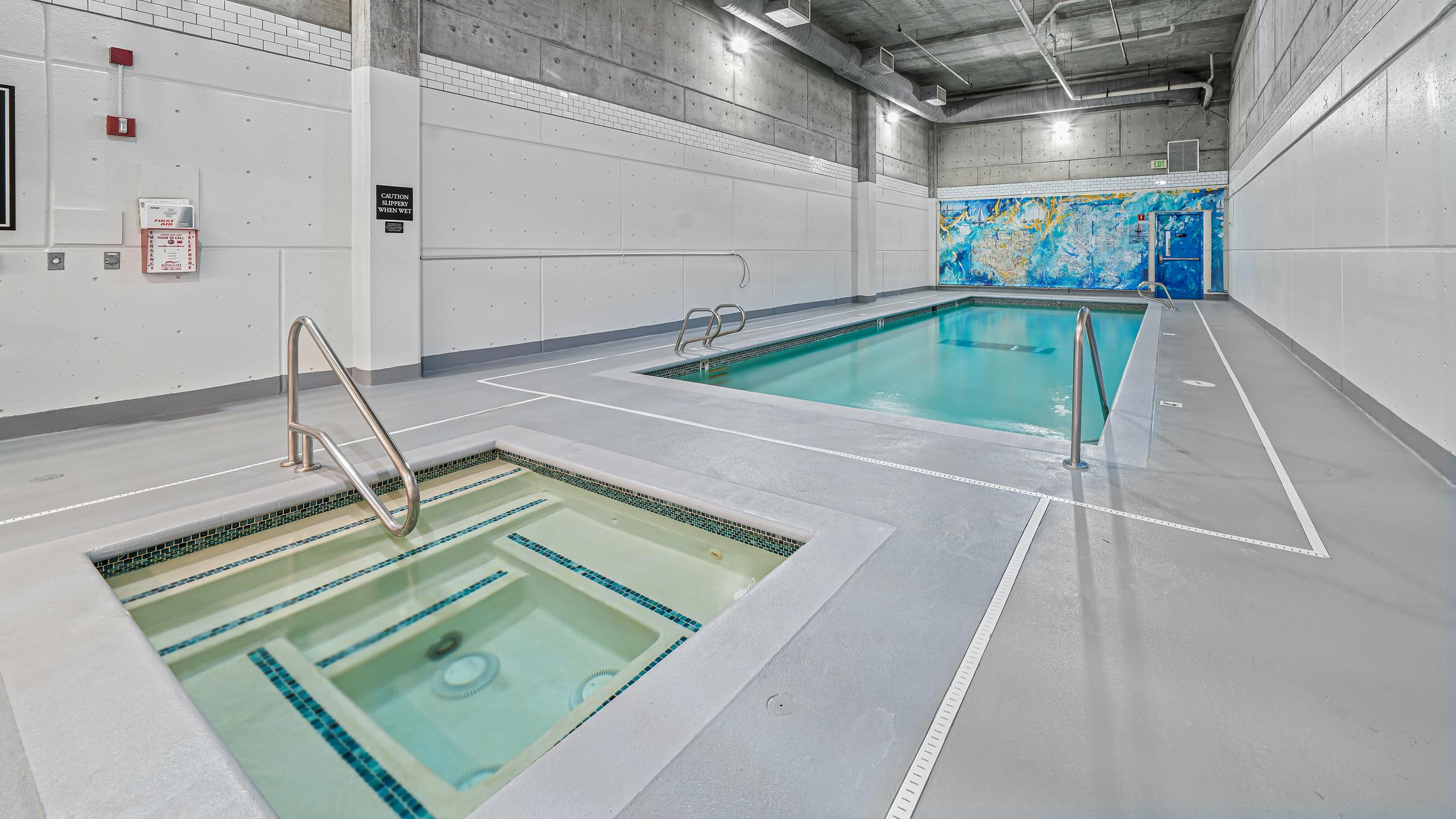 AMLI Bellevue Park indoor pool and spa with colorful mural on the back wall and light grey floors and white walls