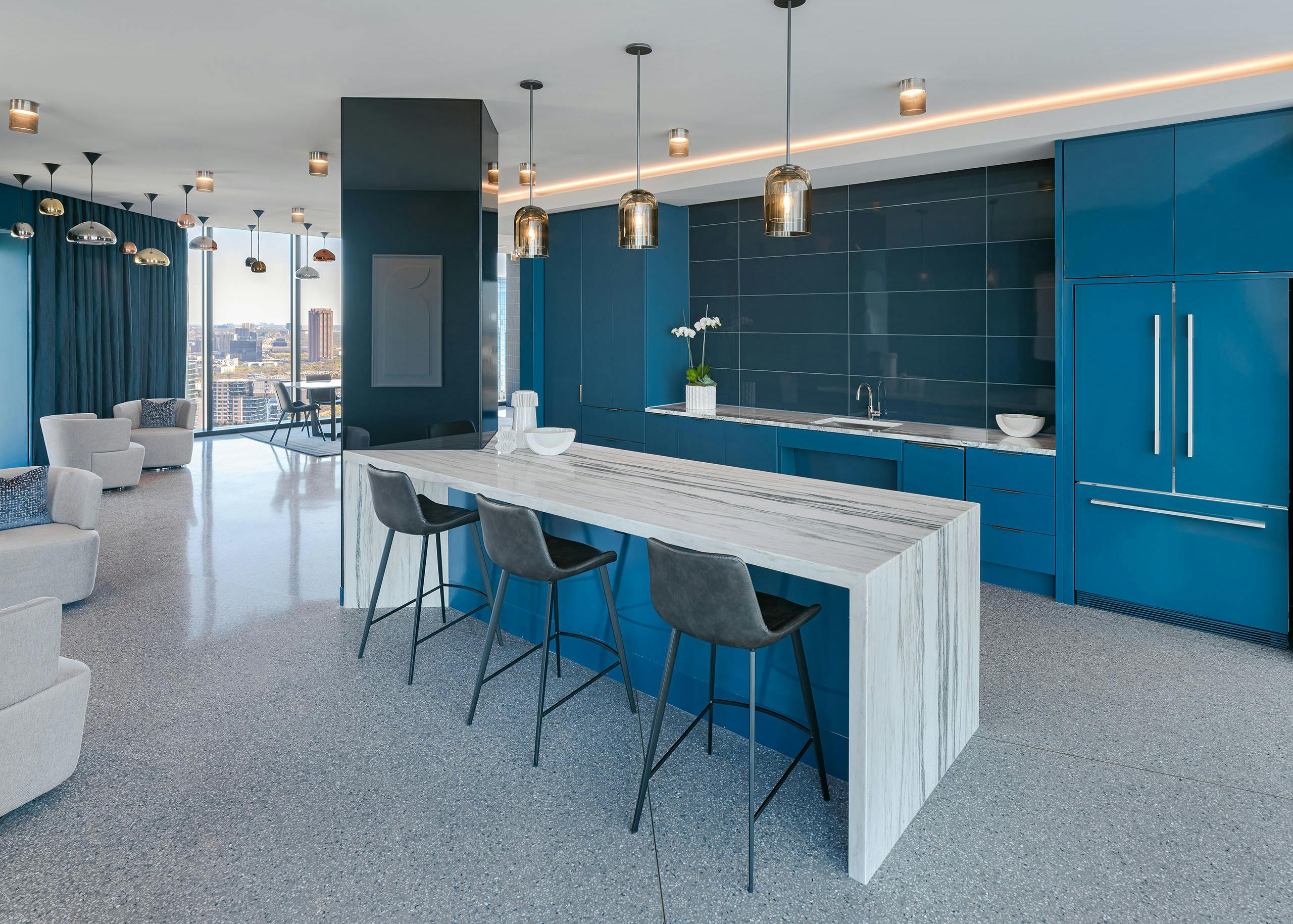 Sky lounge at AMLI Fountain Place apartments with white and grey counter and blue cabinets and dozens of hanging lights