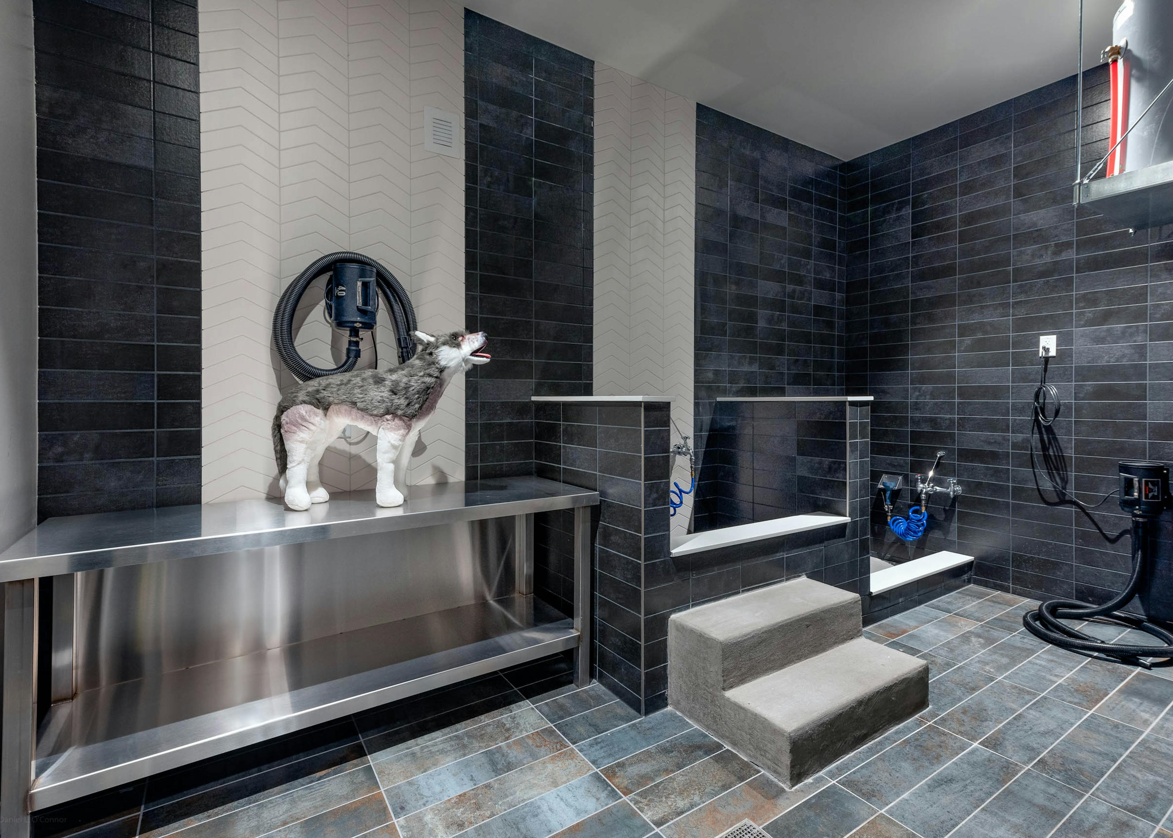 AMLI Art District pet spa with tile throughout and bathing areas with hoses and a large metal table for grooming and drying