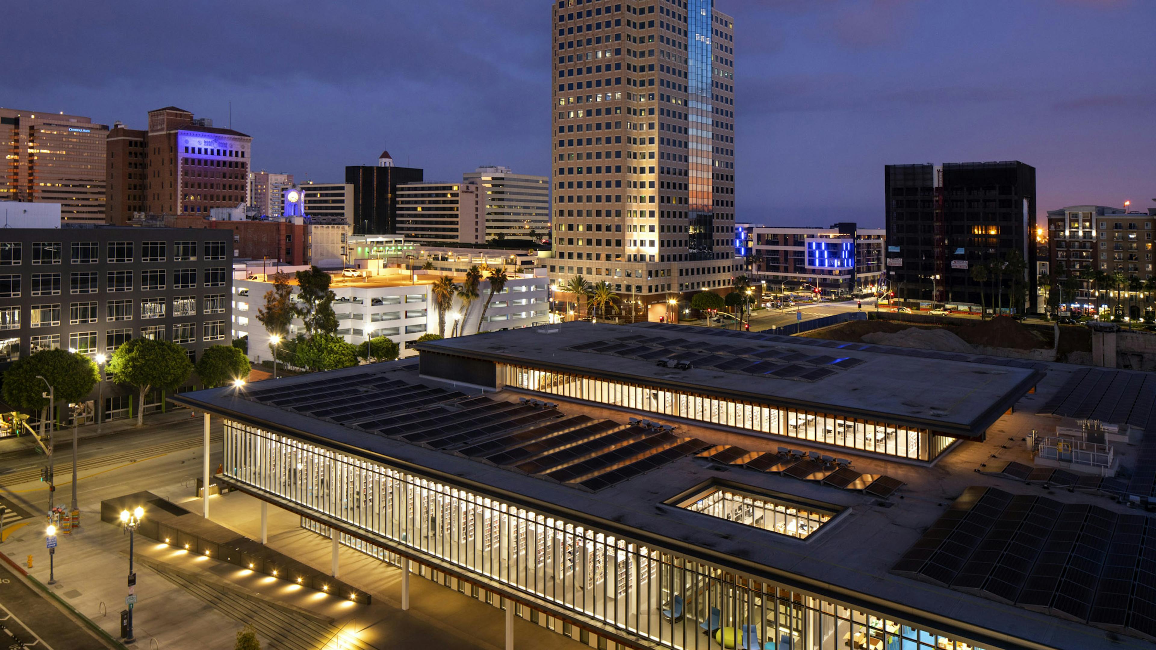 Aerial night view of the lit Billie Jean Library located directly across from AMLI Park Broadway apartment building