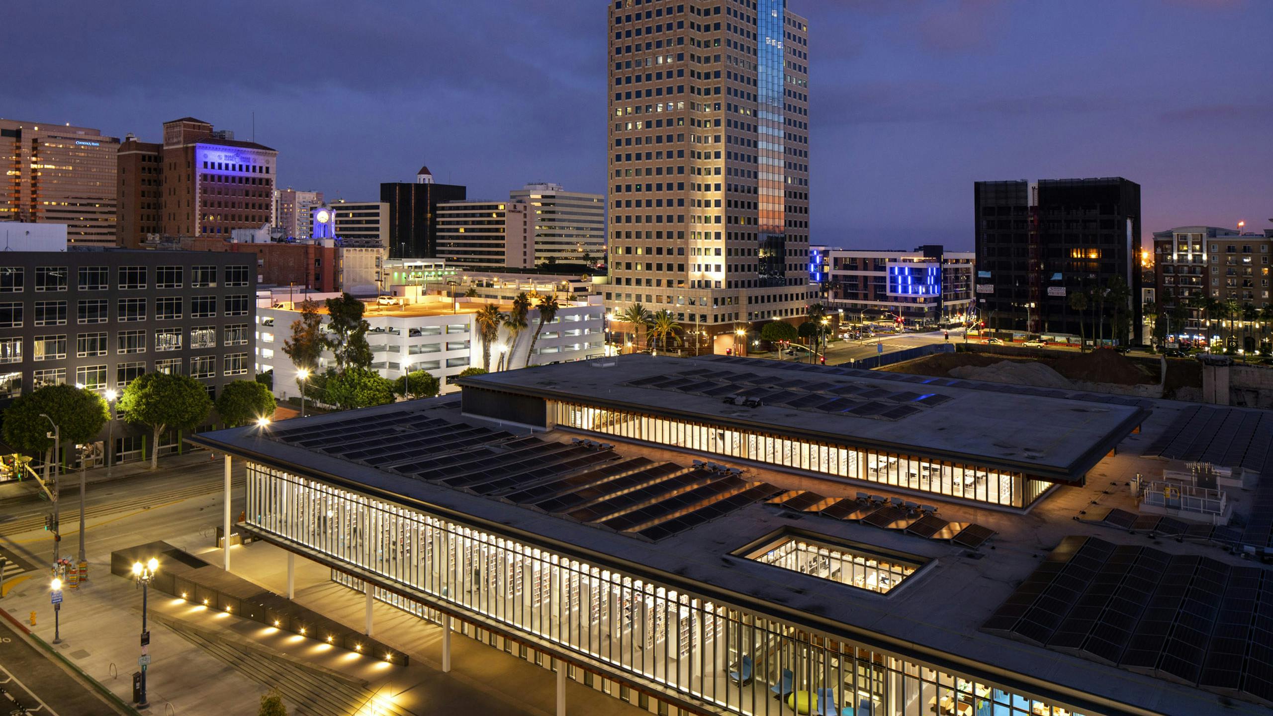 Aerial night view of the lit Billie Jean Library located directly across from AMLI Park Broadway apartment building