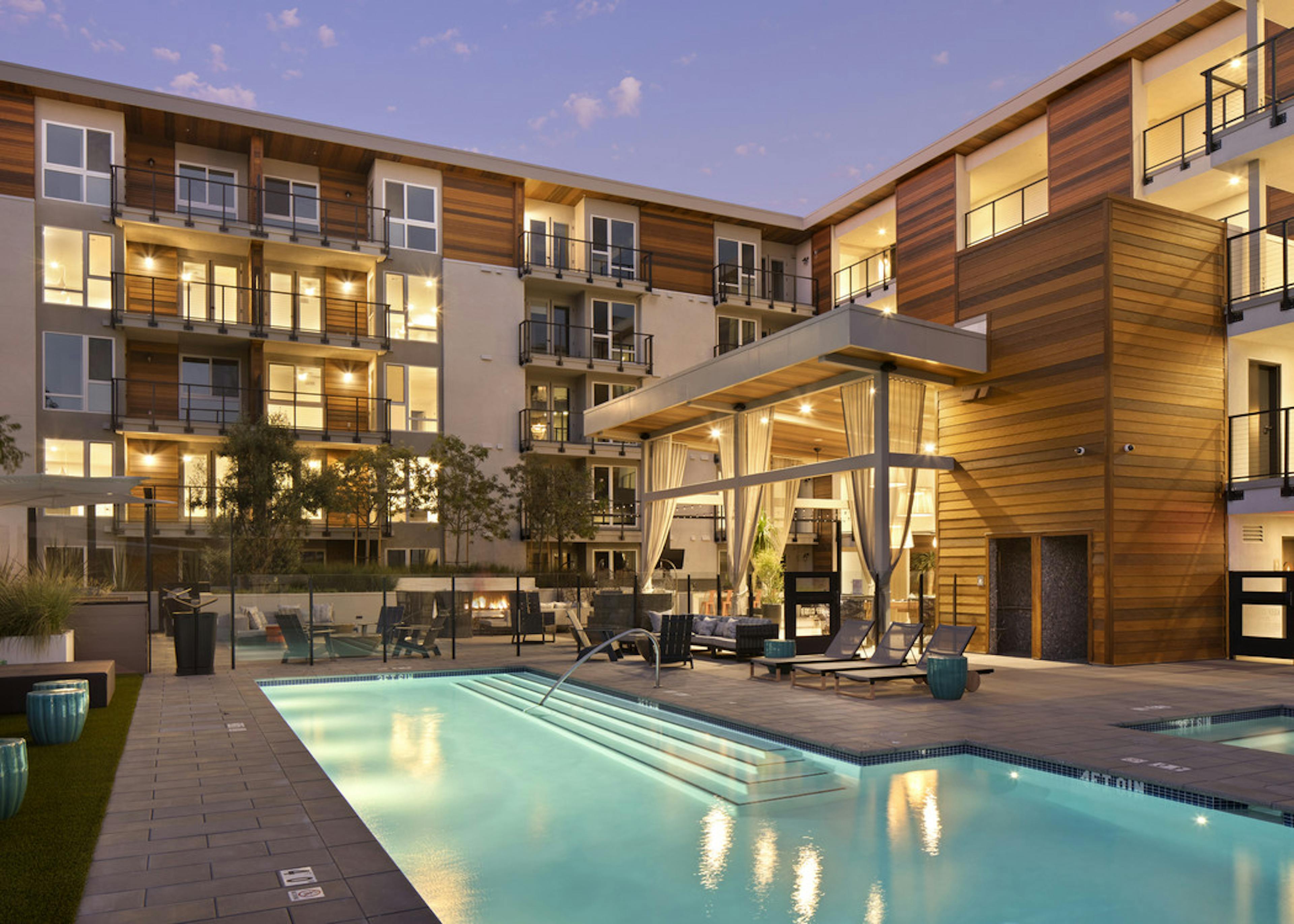  Evening view of AMLI Marina Del Rey landscaped and lit swimming pool area with lounge seating, jacuzzi and entertaining lanai Caption Resort-style salt water pool