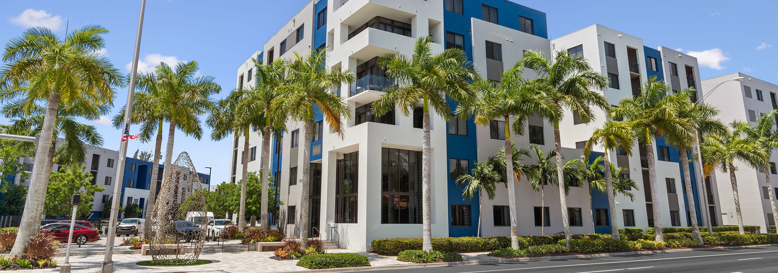 AMLI 8800 apartment building façade with modern design and blue painted accents and wire sculpture and palm trees