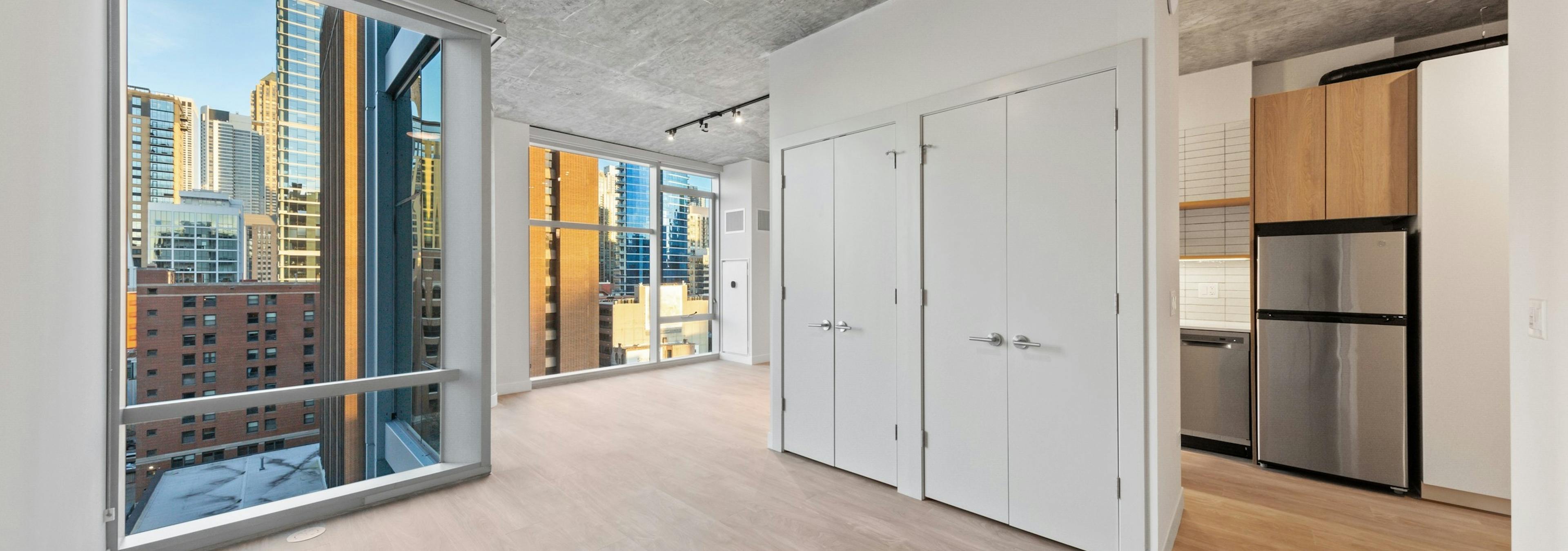 AMLI 808 apartment convertible living area with partial wall separating kitchen and living space surrounded by tall windows