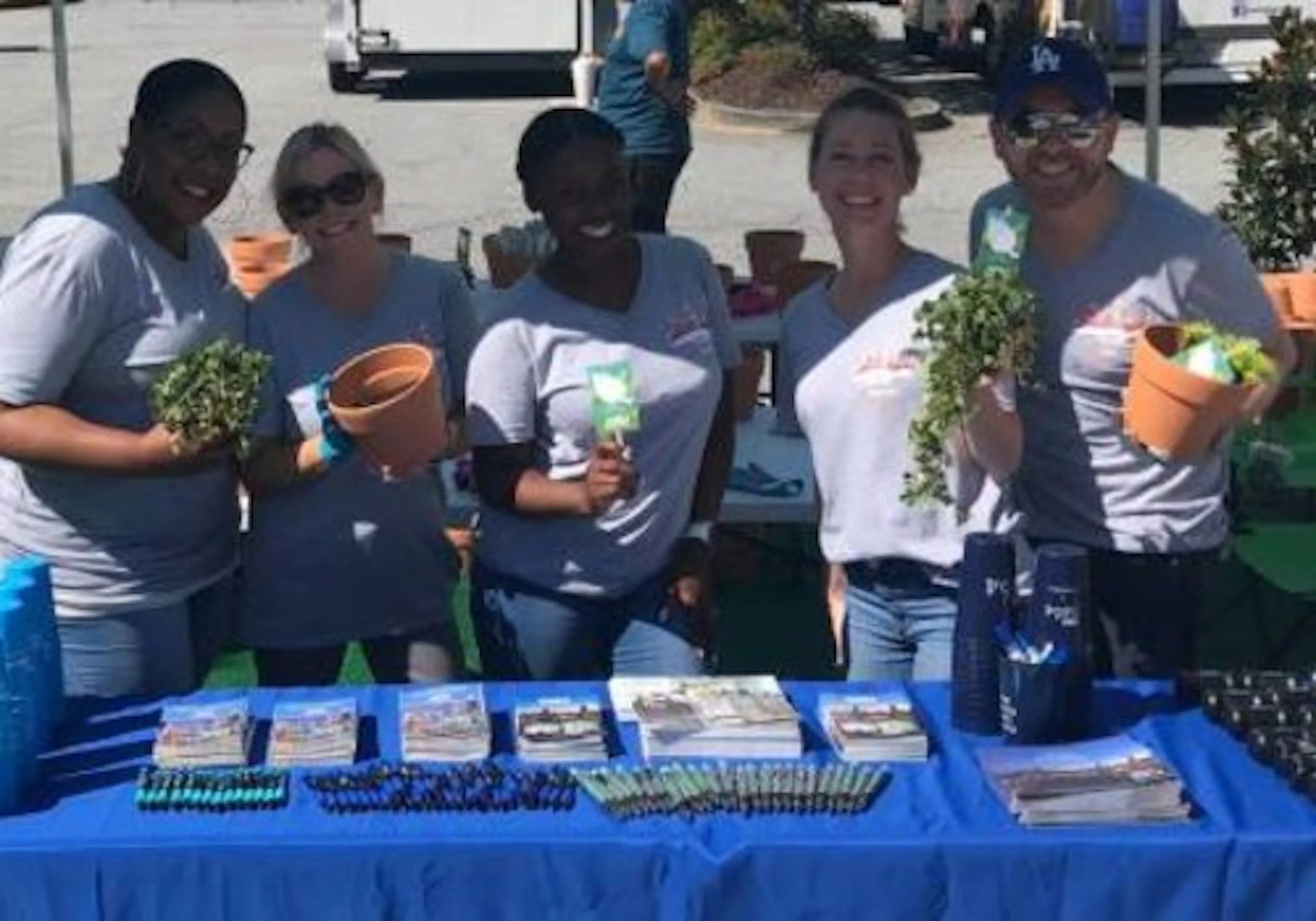 A group of AMLI employees giving away plants and green home resources to residents at a resident planting event
