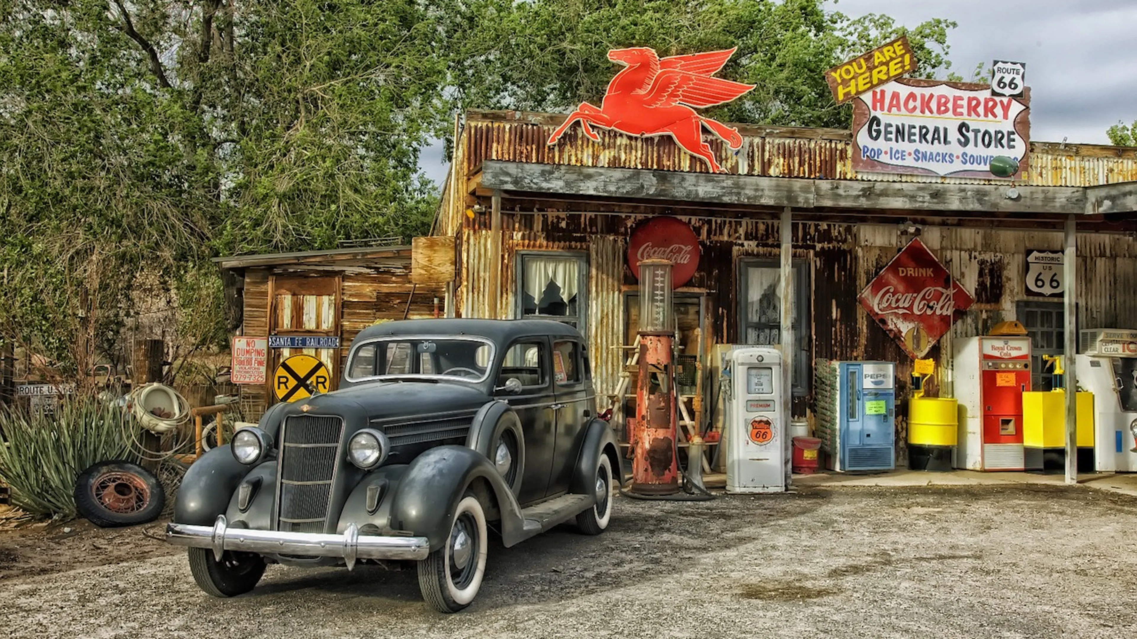 An old car parked outside Hackberry General Store along Route 66 on a sunny day