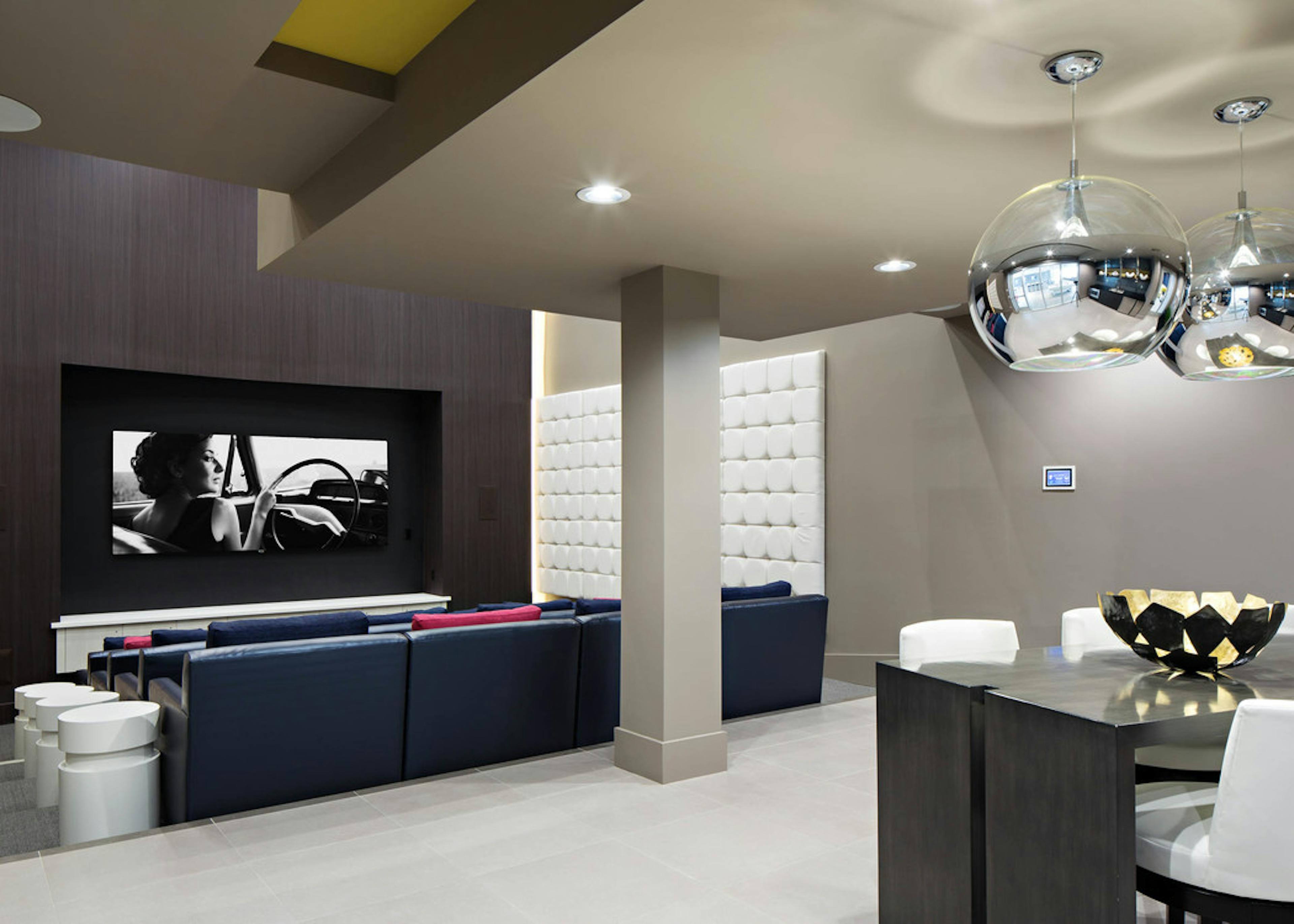 Interior of Hollywood-inspired theater with blue vinyl cushion seating and big screen TV at AMLI Lex on Orange apartments