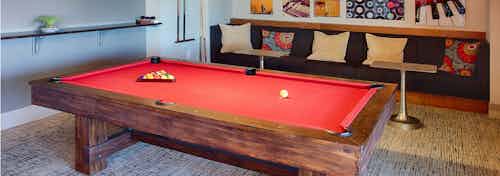 Interior view of the billiards table area at AMLI Denargo Market apartments featuring red felt on the table and wall art work