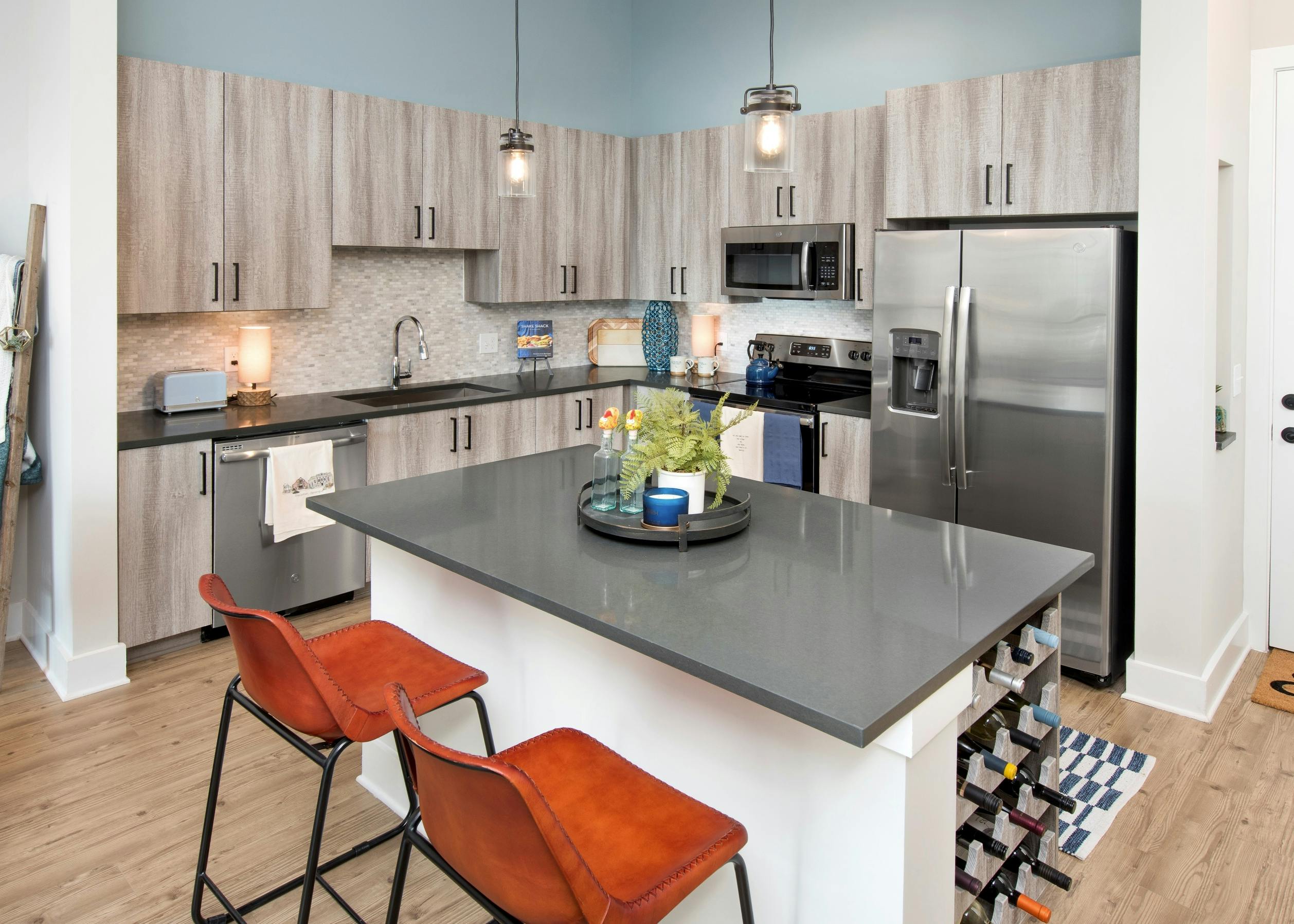 Interior view of AMLI Dectaur apartment kitchen with island and stainless steel appliances.