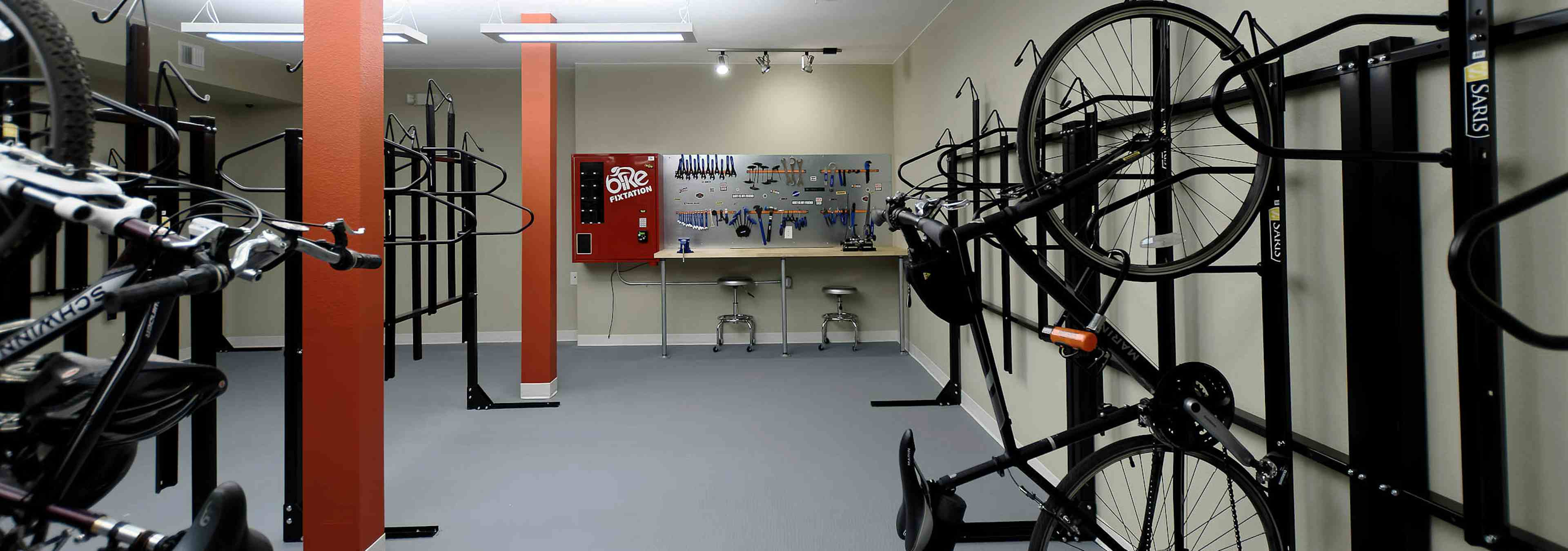 Interior of the bike repair room area at AMLI Dry Creek apartments with view of work station table with tools and bike racks