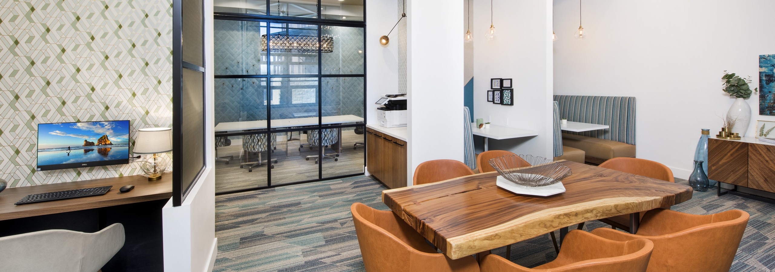 Interior of fully equipped tech center at AMLI Decatur with computer station and printer and table with six chairs and booths